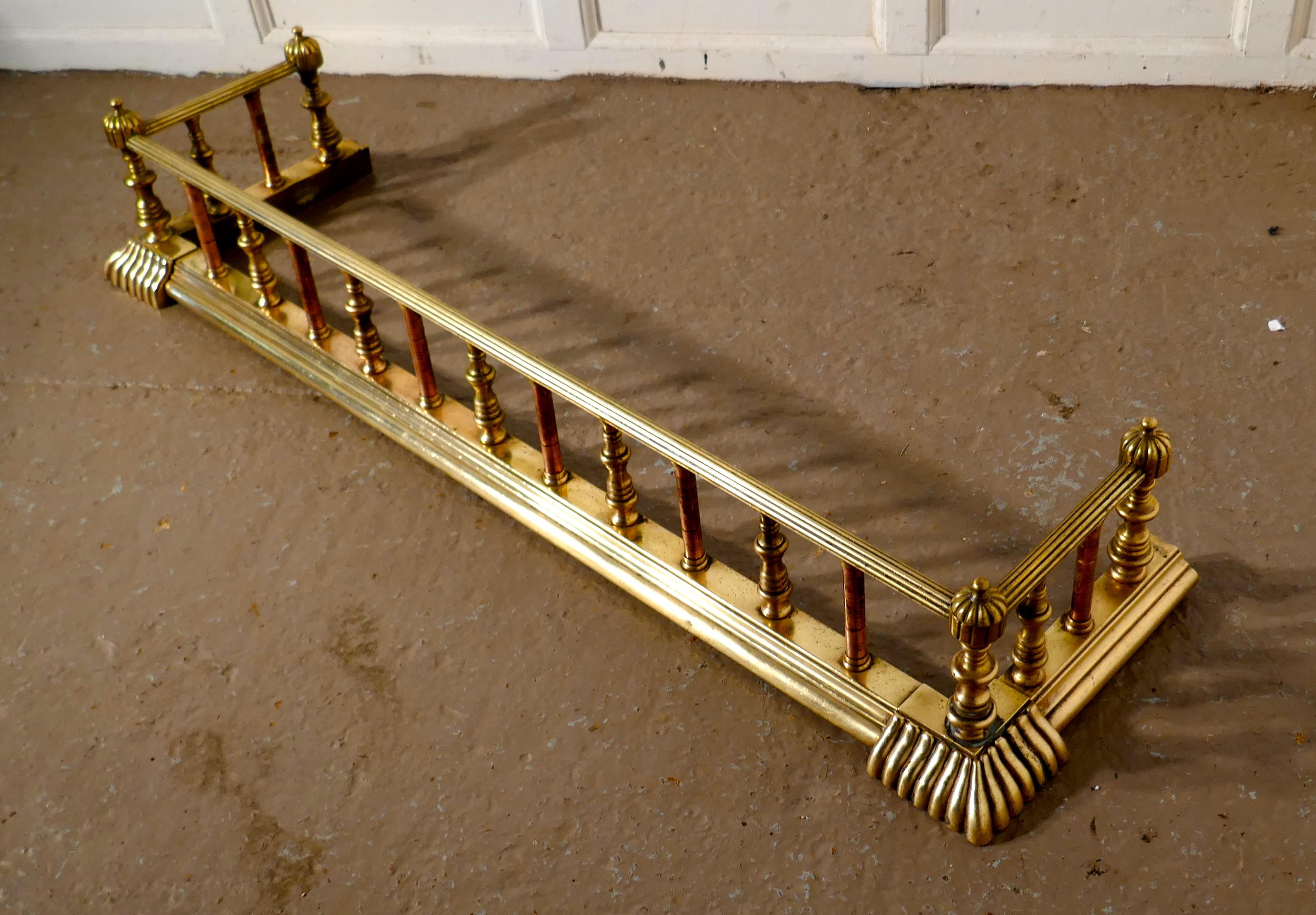 Large 19th century Arts & Crafts brass and copper fender. 

This is a good quality brass fender it has a deep shaped base and chunky brass and copper spindles, it has very decorative fluted corners at the floor
The fender has molded decoration