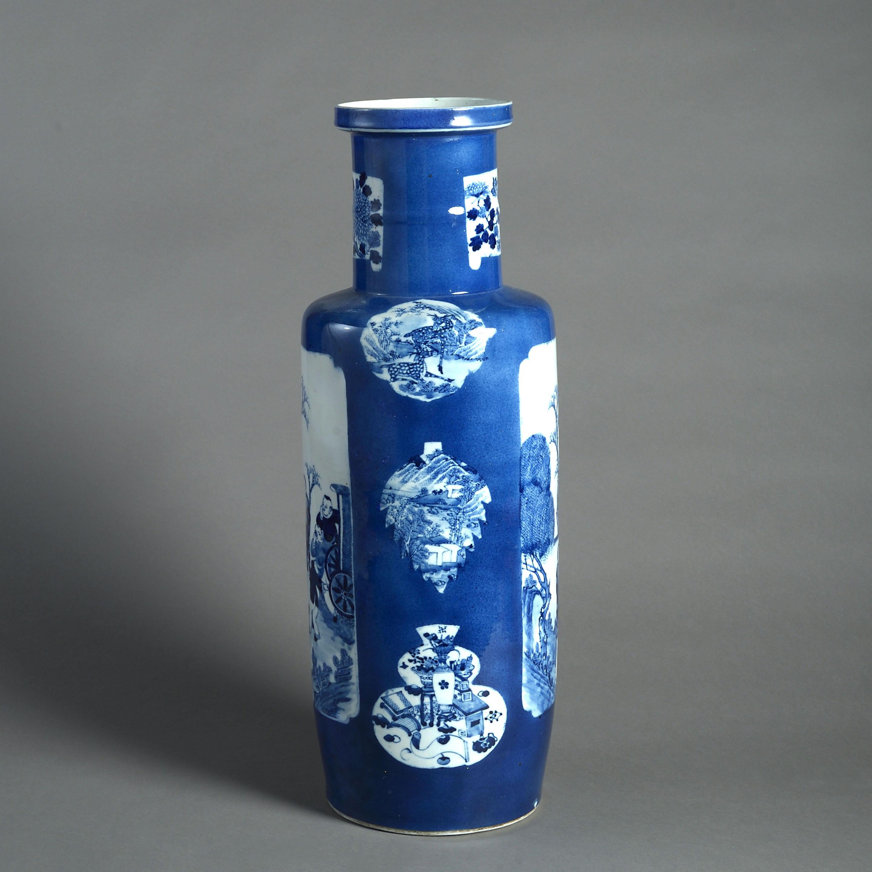 A large-scale blue and white porcelain rouleau vase, of good scale and decorated with cartouches on a powder blue ground. 

Qing dynasty. With invisible restoration.