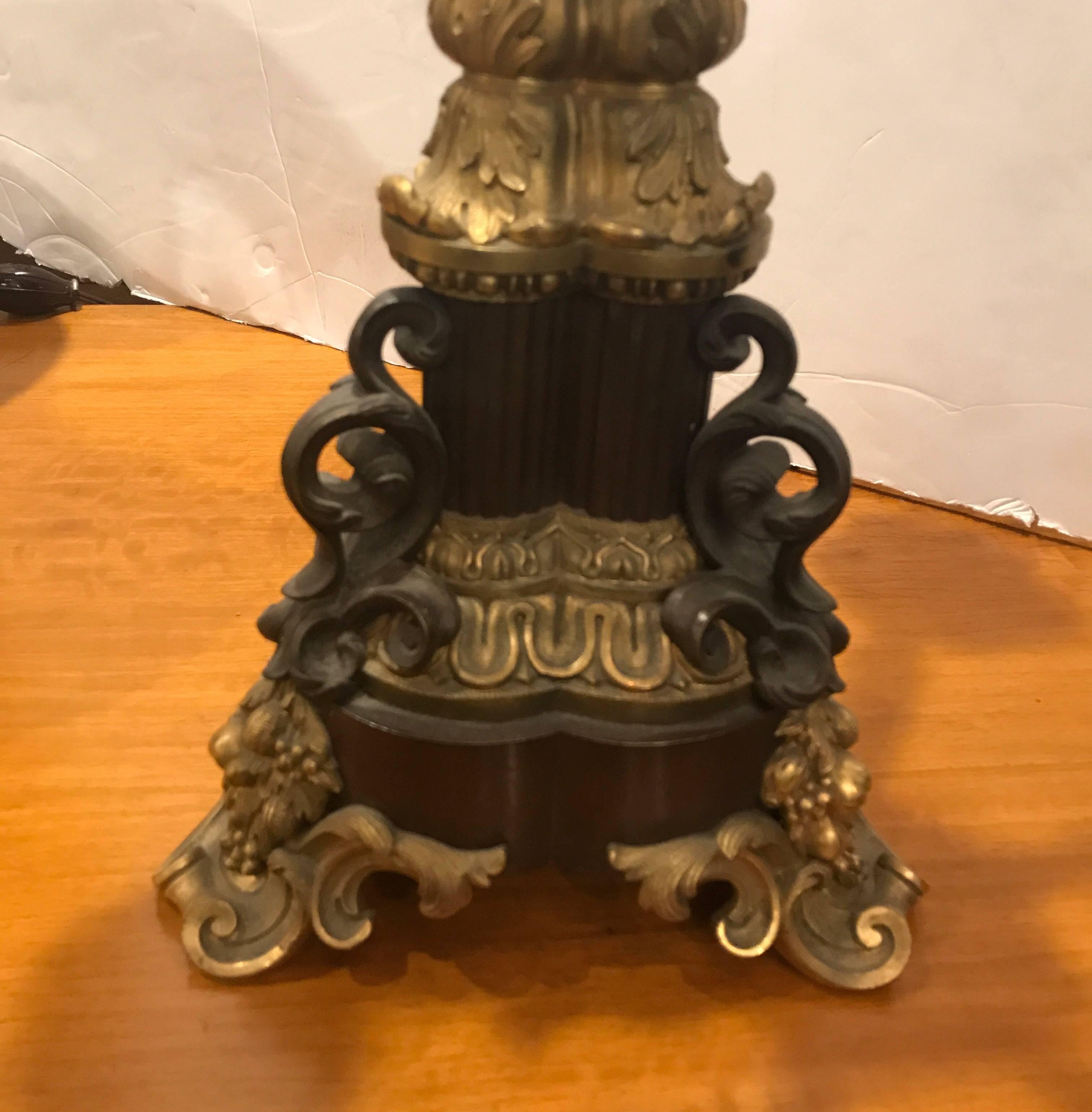 Impressive patinated bronze and ormolu-mounted tall candelabra now electrified. The 19th century candelabra with original finish converted to electric, circa 1920. The elaborate top with triple rod center column resting of finely cast ormolu feet.