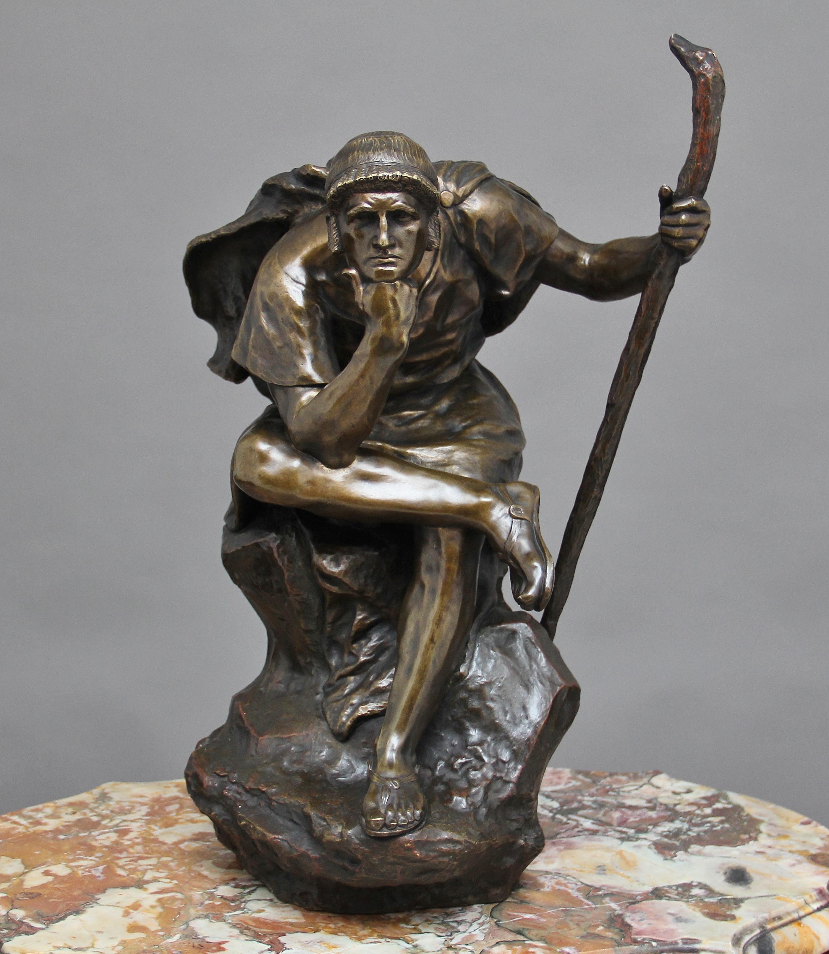 A large 19th century bronze of “Oedipus meditating” by the French sculpture Henri Daniel Contenot, the cloaked figure sitting on a rock surface, cross legged with a stick in hand meditating. On the rock surface there is the foundry mark which reads