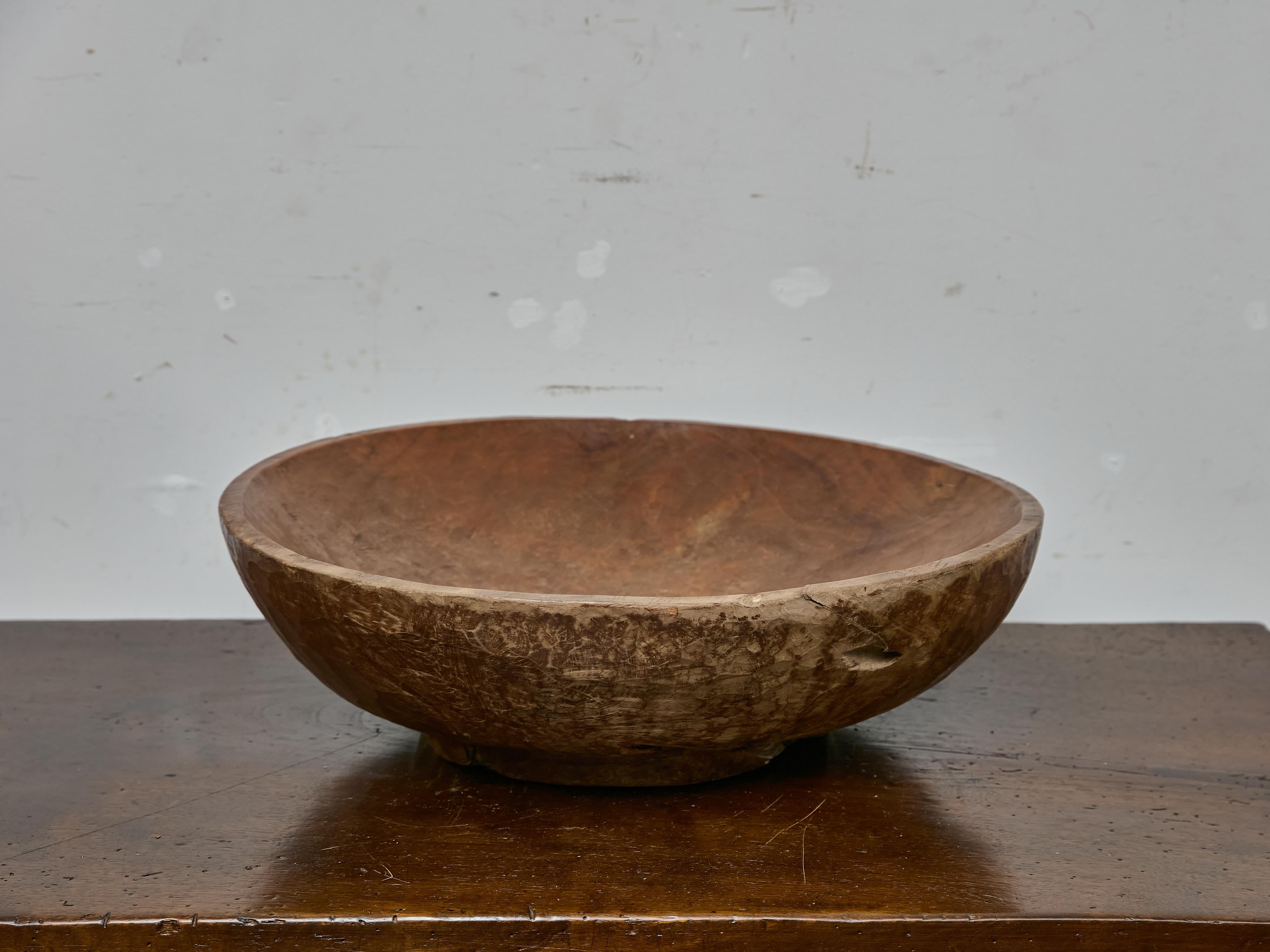 A substantial hand-carved burl walnut bowl from the 19th century, notable for its generous proportions, richly textured grain, and honest signs of age and use. Measuring over 26 inches in diameter, this sculptural wooden vessel was likely used as a