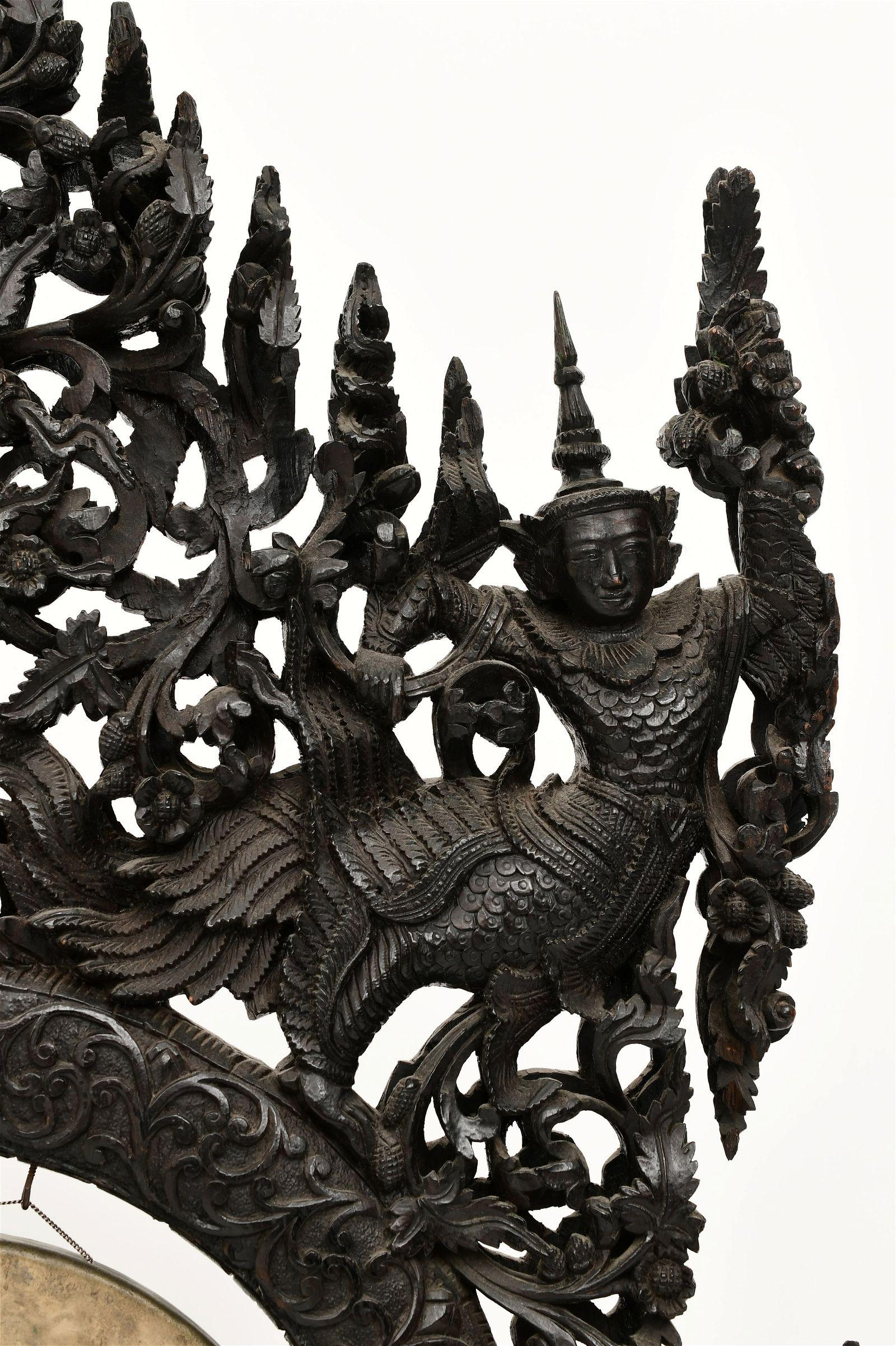 19th century ceremonial gong with exquisite carvings of dragons, mythological figures, foliate and floral motifs and seated figure at center.