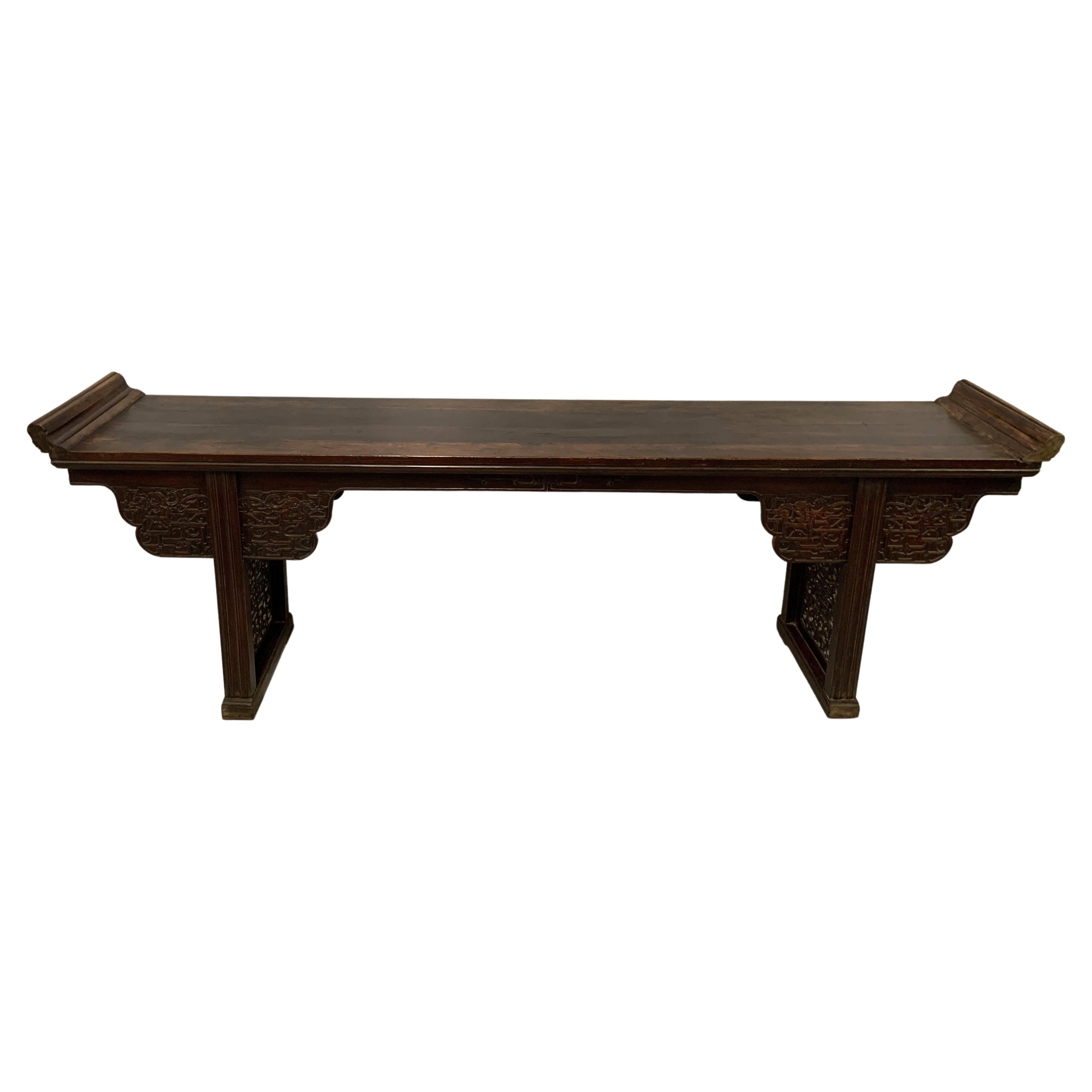 A large finely carved elmwood Chinese alter table from the late 19th century. The top is a solid piece of old grown elmwood and the table has a wonderful old patina. This table is highly decorative and functional as it is very narrow and long, a
