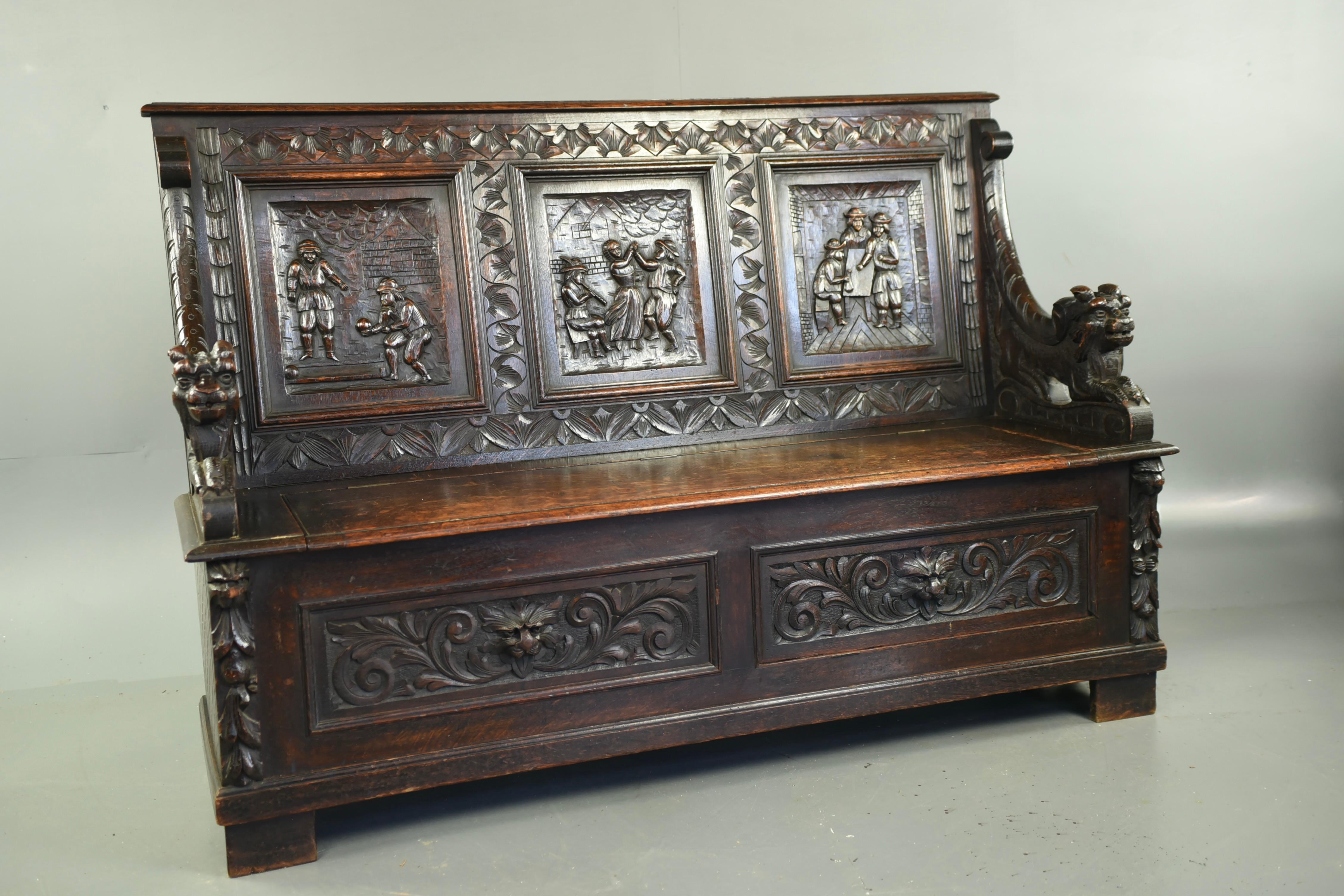 Good Quality Large 19th century large carved oak box settle .( 6ft wide )circa 1870
This large three panel settle has Three fine deep carved Tavern scenes with dragon carved arms .The lift up seat provides a good amount of storage ideal for boots
