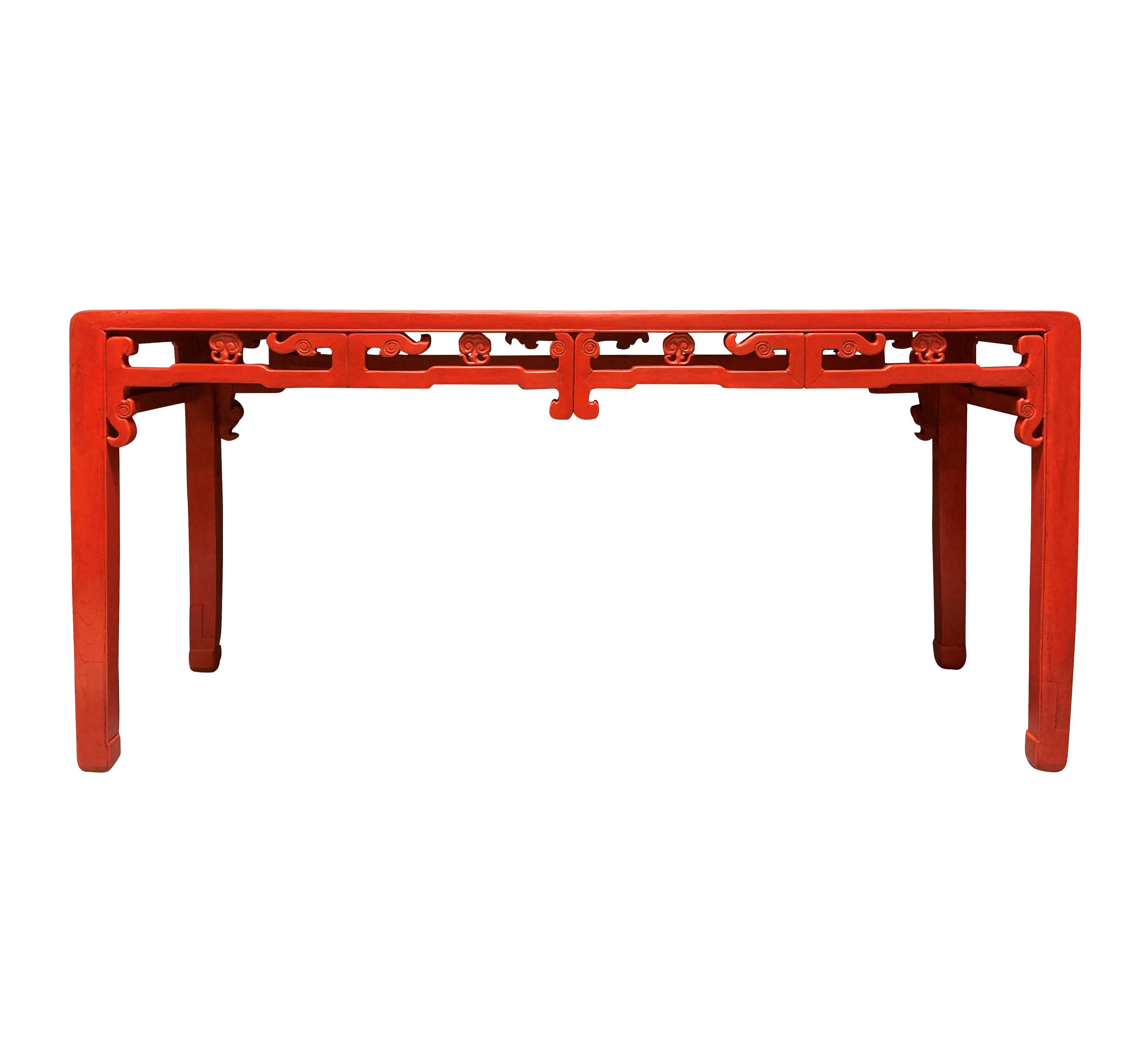 A large Chinese Qing Dynasty carved elm console table in scarlet. Carved throughout with pierced friezes, with different designs front and back, which means it can be reversed.