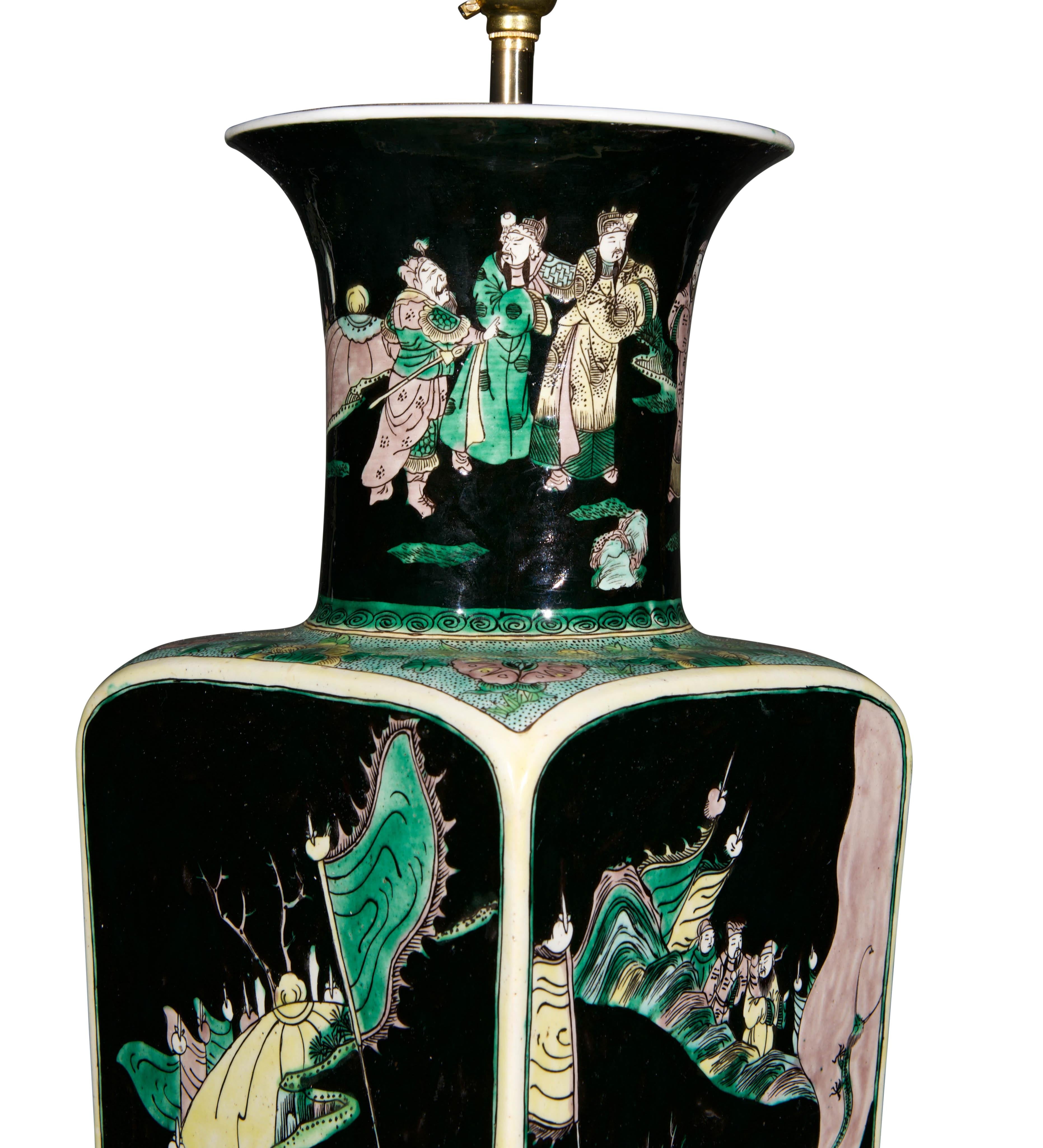 A fine late 19th century Qing dynasty vase, of square taering form with a flared circular neck, decorated throughout with the famille noire palette with green detailing, with seven warriors in a continuous scene in a stylised landscape, now mounted