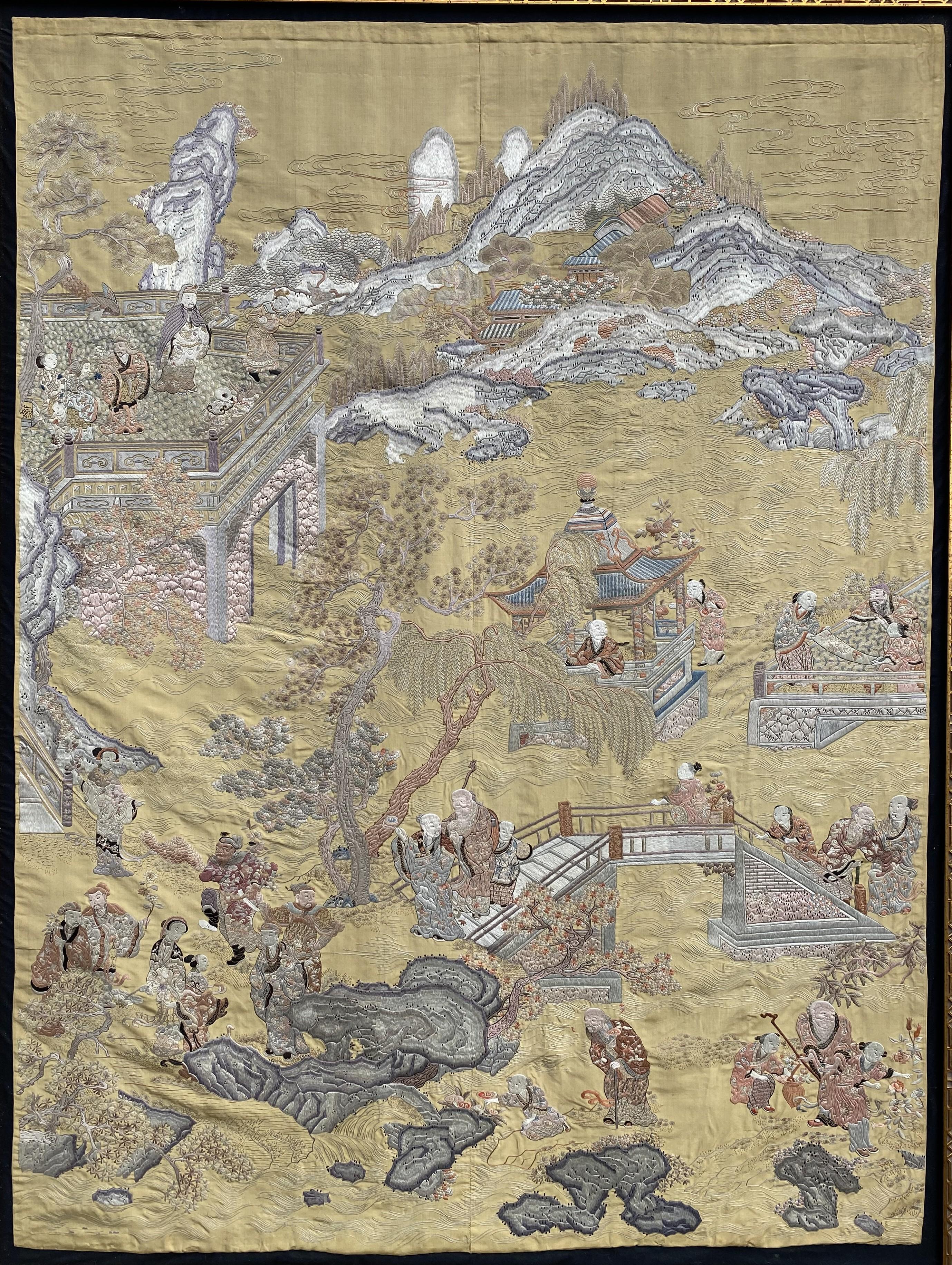 A wonderful example of a hand crafted Chinese Kesi silk and needlework tapestry panel with intricate designs including folkloric figures, buildings, trees,  and countryside landscapes, mounted and sewn with a black silk border and housed in a