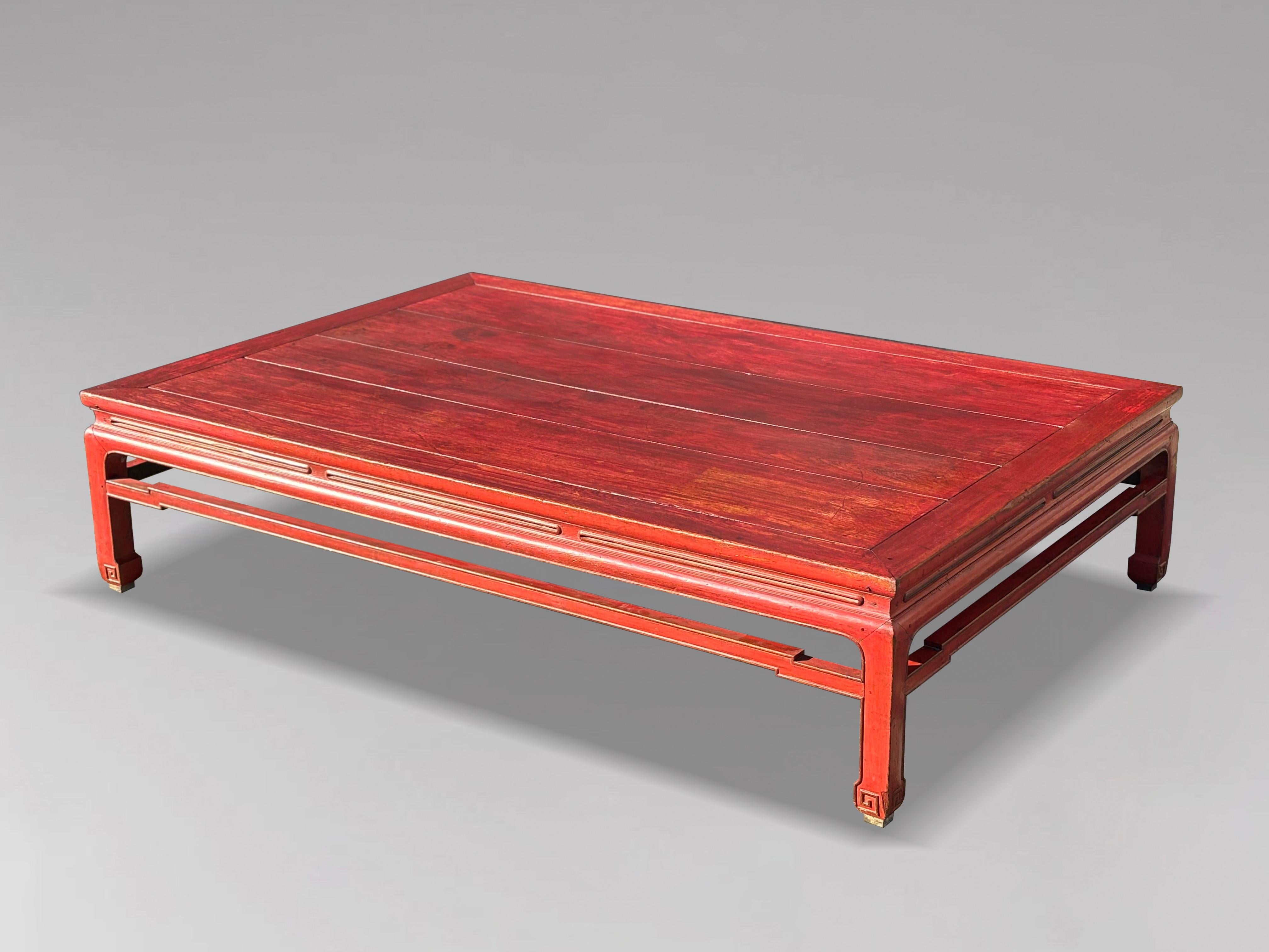 Ce lit ou table basse chinois laqué rouge du début du 19e siècle date des années 1800. La laque rouge présente une patine douce, caractéristique de l'art traditionnel de la laque chinoise. La table présente un plateau à panneaux épuré, entouré d'une
