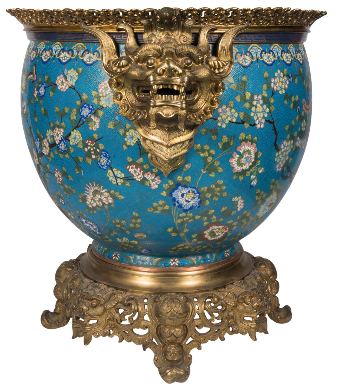 A very large and rare early 19th century Chinese cloisonné enamel fish bowl / jardiniere, having wonderful later French gilded ormolu mounts of mythical dragon like mask handles. The beautiful enamel colors to the body, depicting exotic blossom