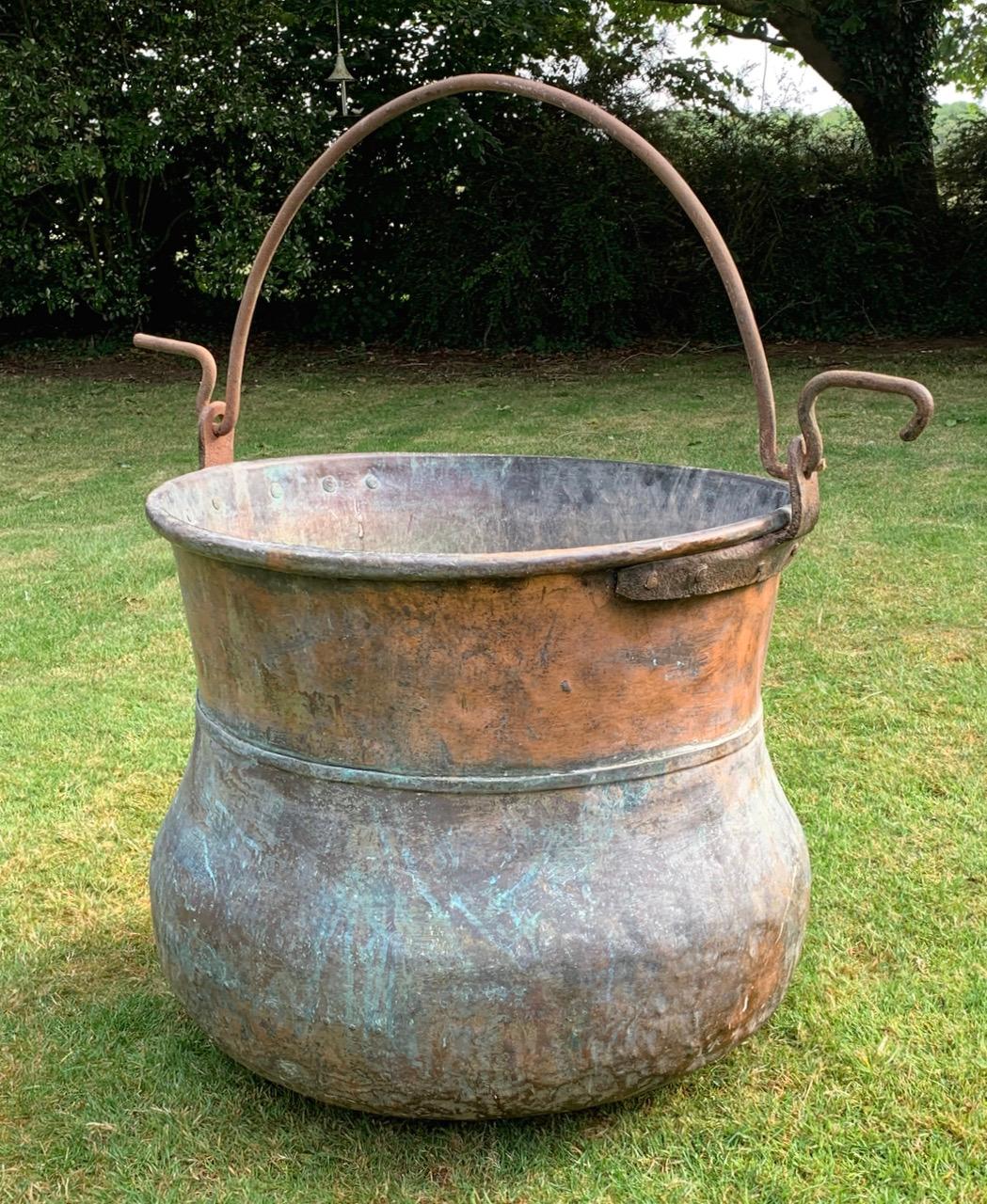 A lovely 19th century French copper cauldron vat with original iron handle. It is 74cm high to the rim not including the handle. It has a couple of period repair patches with rivets which adds to the look. It is not water tight but will make a