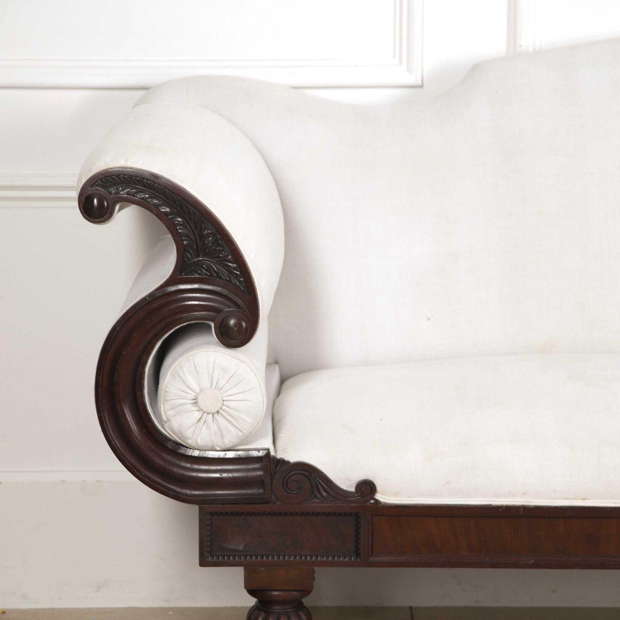 Large English late Regency mahogany sofa.
It has been reupholstered in antique natural linen that highlights the mahogany structure wonderfully. The linen has some light marks but this does not detract from its timeless style. 
Featuring scrolled