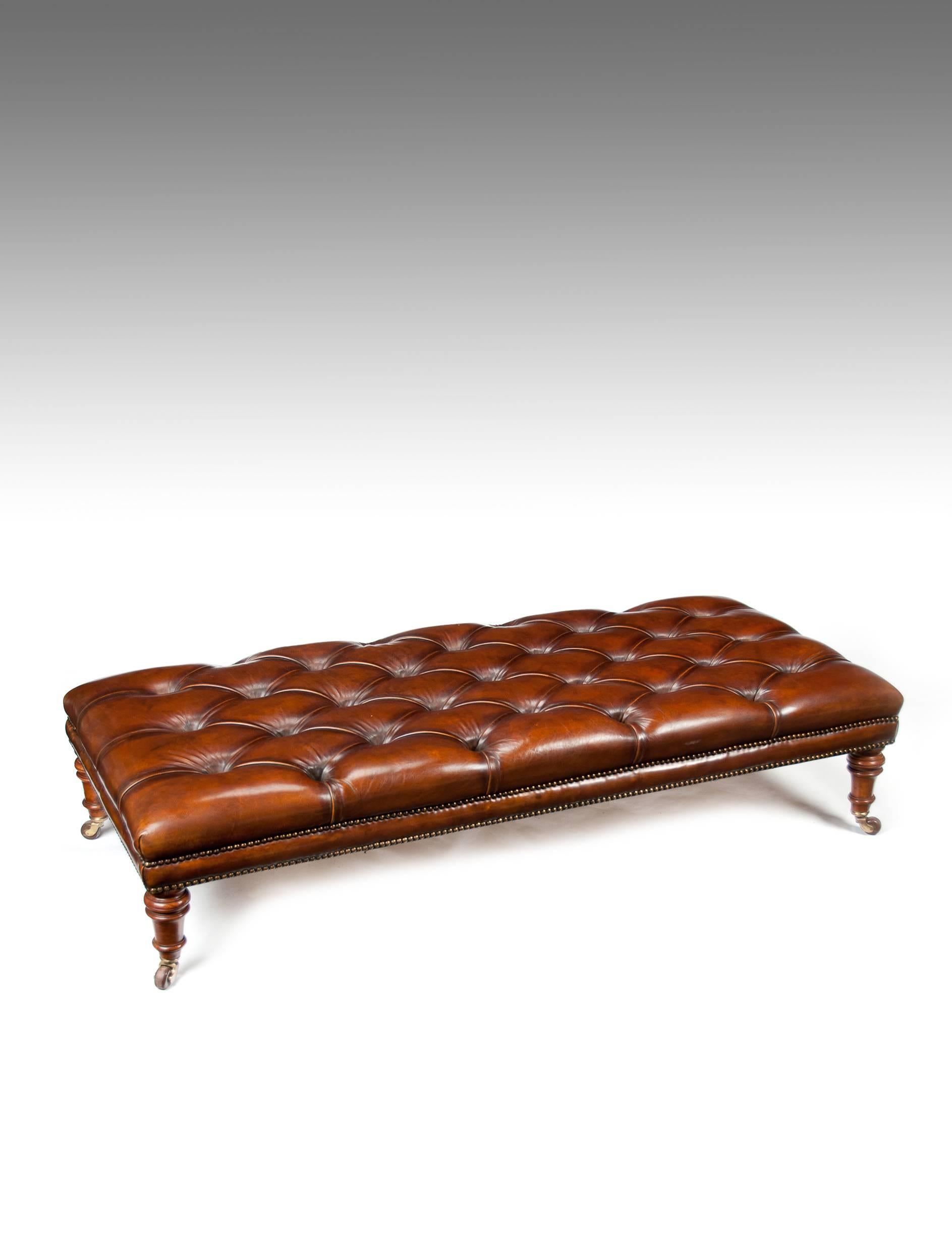 A large 19th Century walnut deep buttoned leather upholstered stool.

Of large proportions having been recently upholstered in a deep buttoned hand-dyed leather with a double brass close nailed studwork finish. Raised on original ring turned walnut