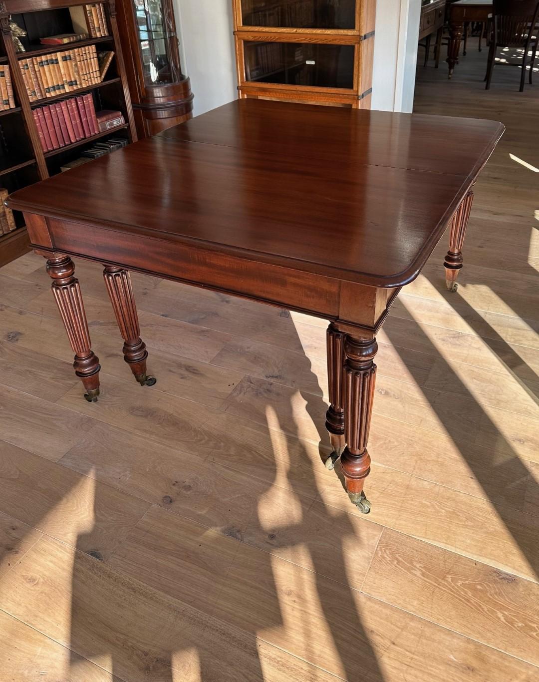 Beautiful large antique mahogany dining table with 3 original extra leaves. Standing on brass wheels. It is a table from the period of George IV. Beautiful warm color of the beautiful mahogany. The table can be slid apart. And the  leaves are