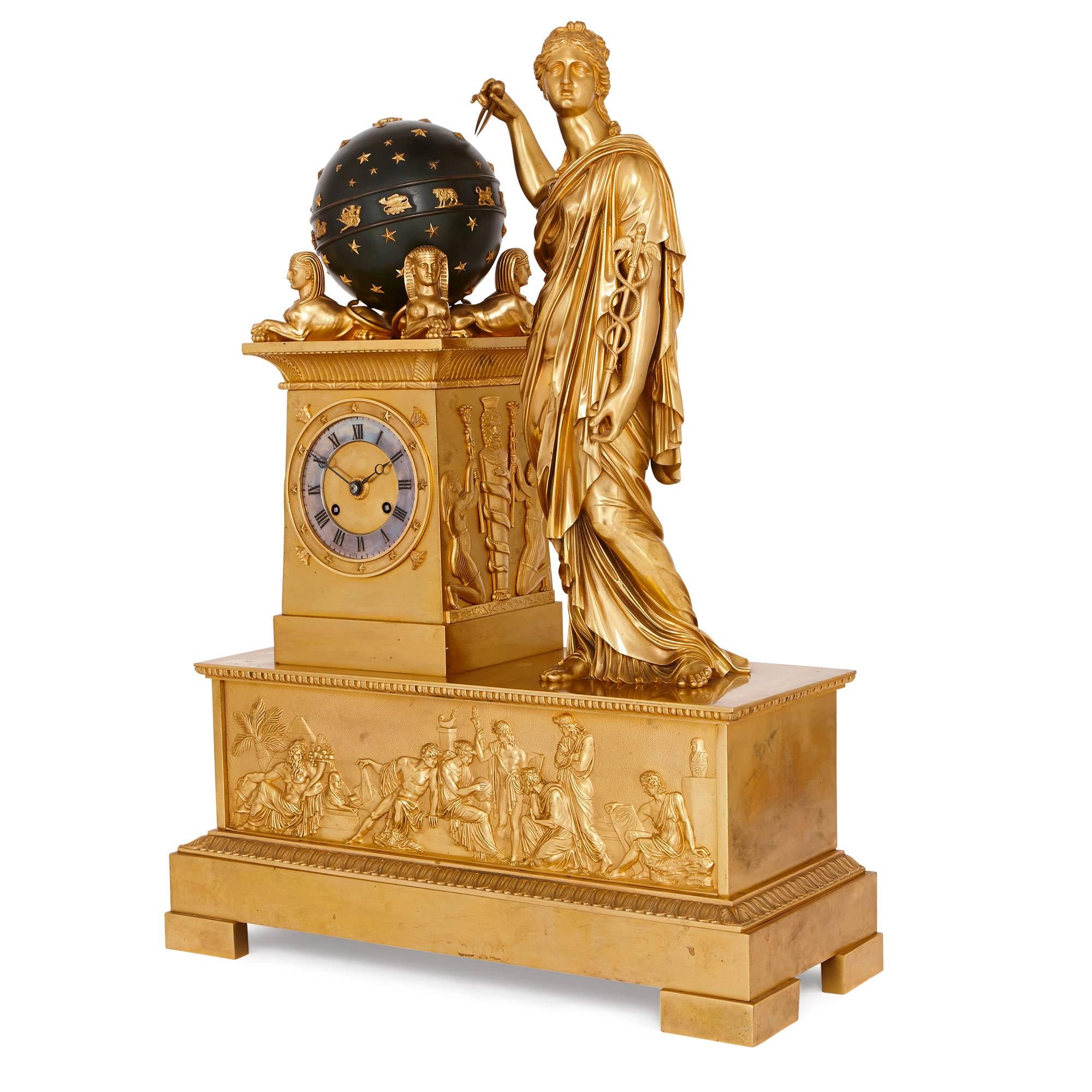 This exquisite mantel clock is crafted in ormolu, and styled in typical fashion for the French Empire period, with strong influences of Classicism and Egyptian Revivalism. The base is set upon a rectangular form plinth with four block feet and a