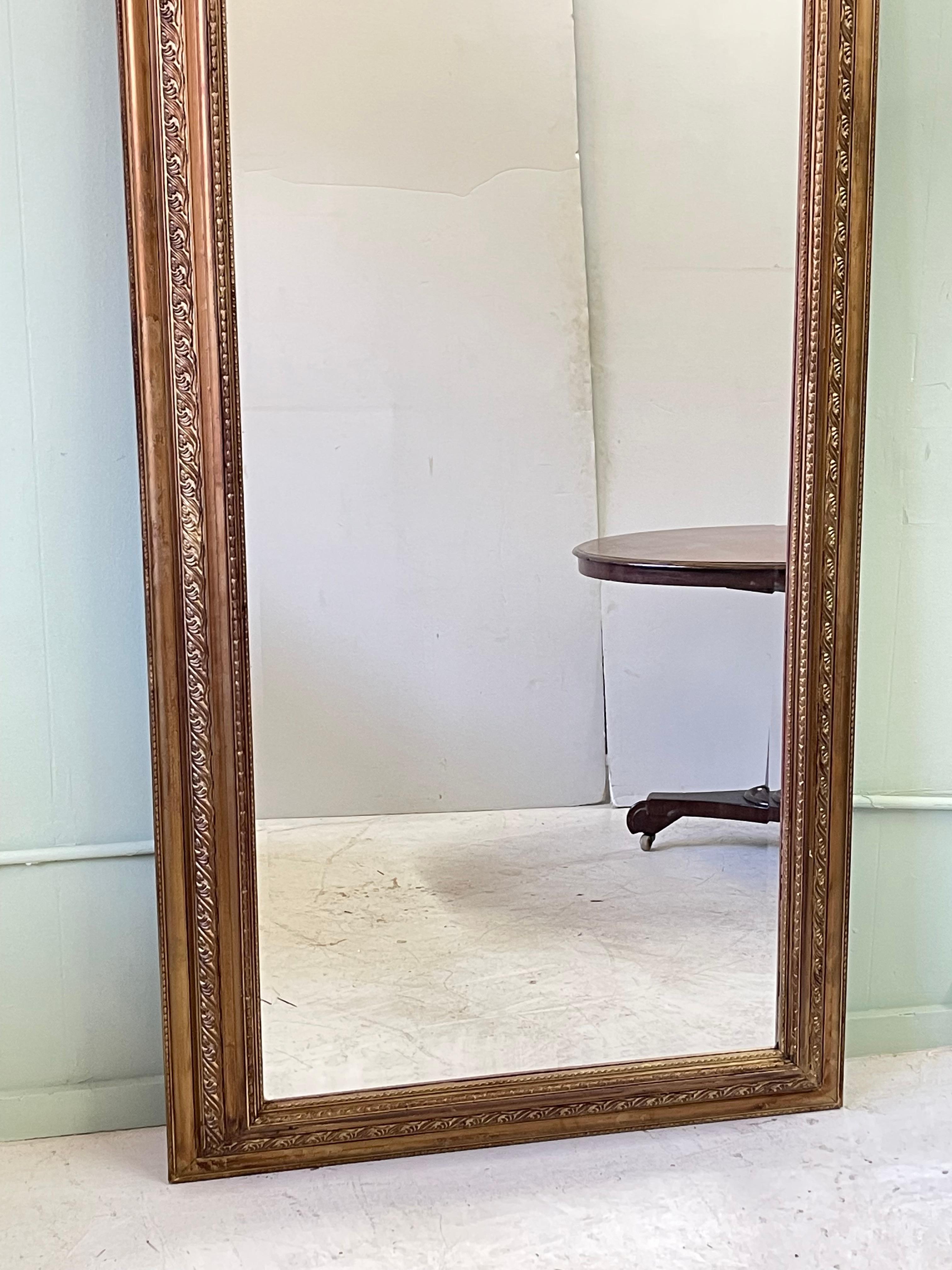 19th Century English wall mirror from the Victorian period having a wonderful acanthus decorated frame and holding a large piece of beveled glass. 

The frame measures 78.38