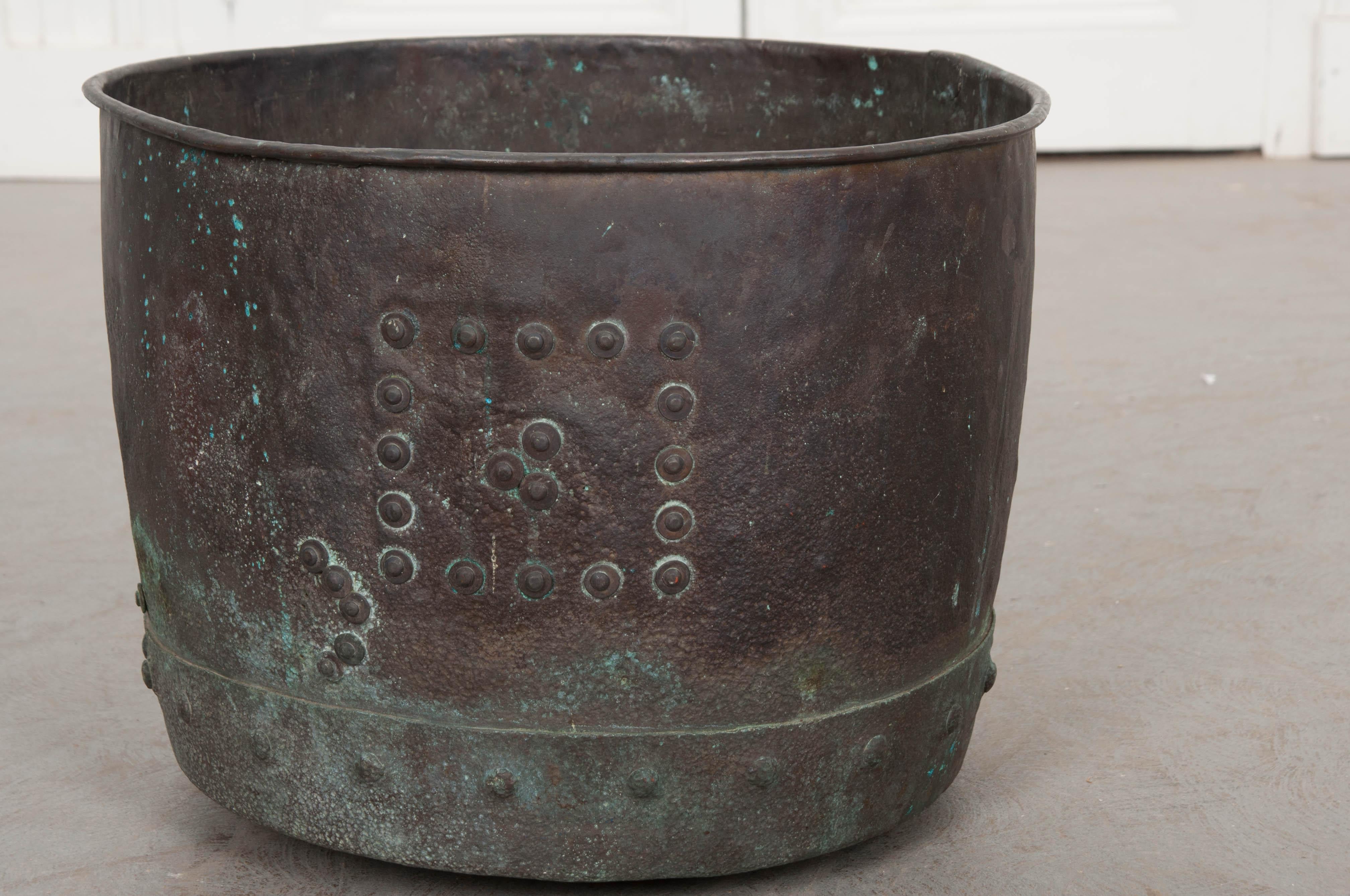 A beautifully patinated copper pot from England, circa 1880. The vessel has undergone some repairs at some points in its lifetime, as seen in the interesting patches secured with rivets. The metal has oxidized and turned a beautiful blue-green