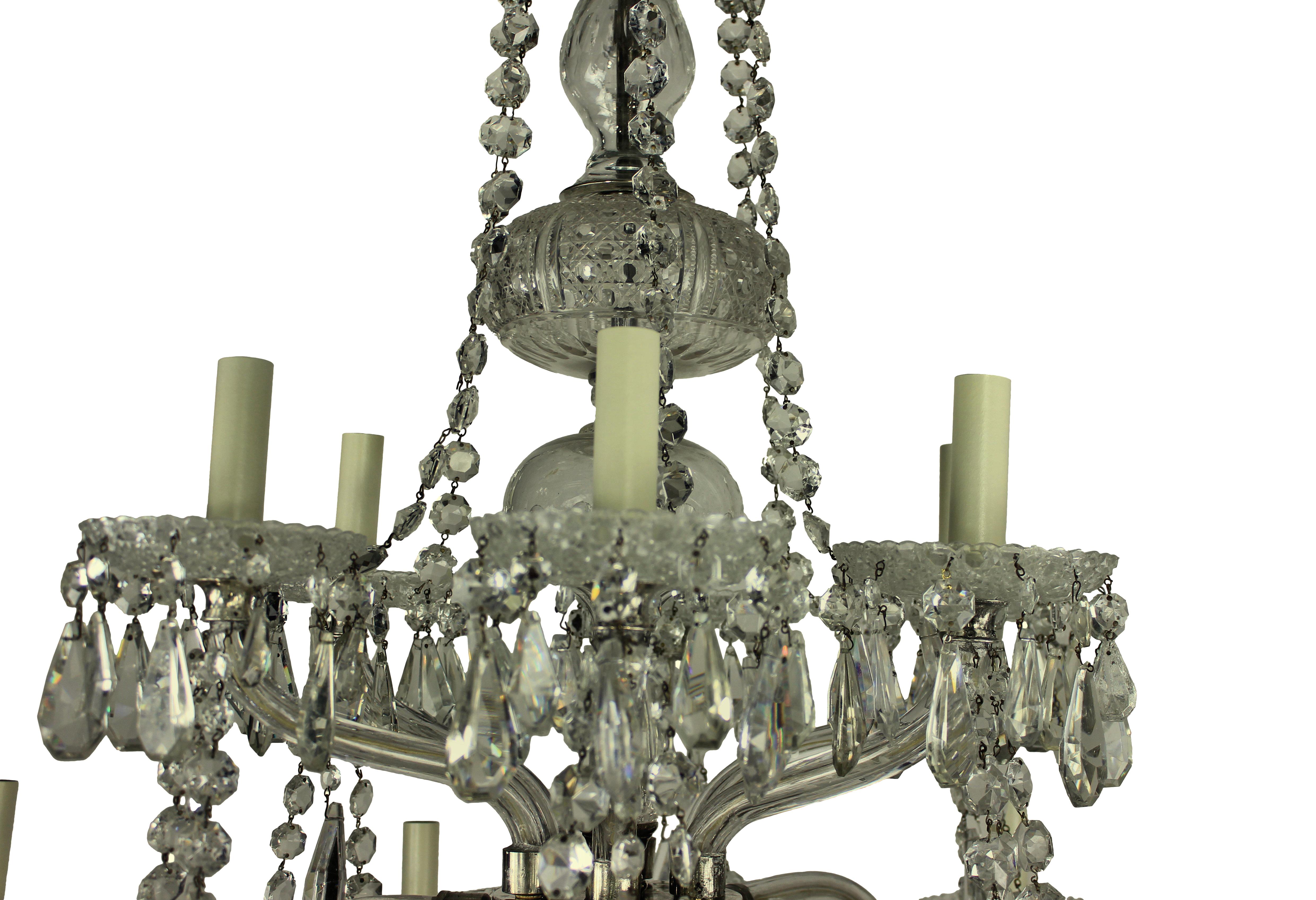 A large English cut-glass chandelier of good quality. Of six down-swept and six up-swept arms, decorated heavily with swags and pendant drops.