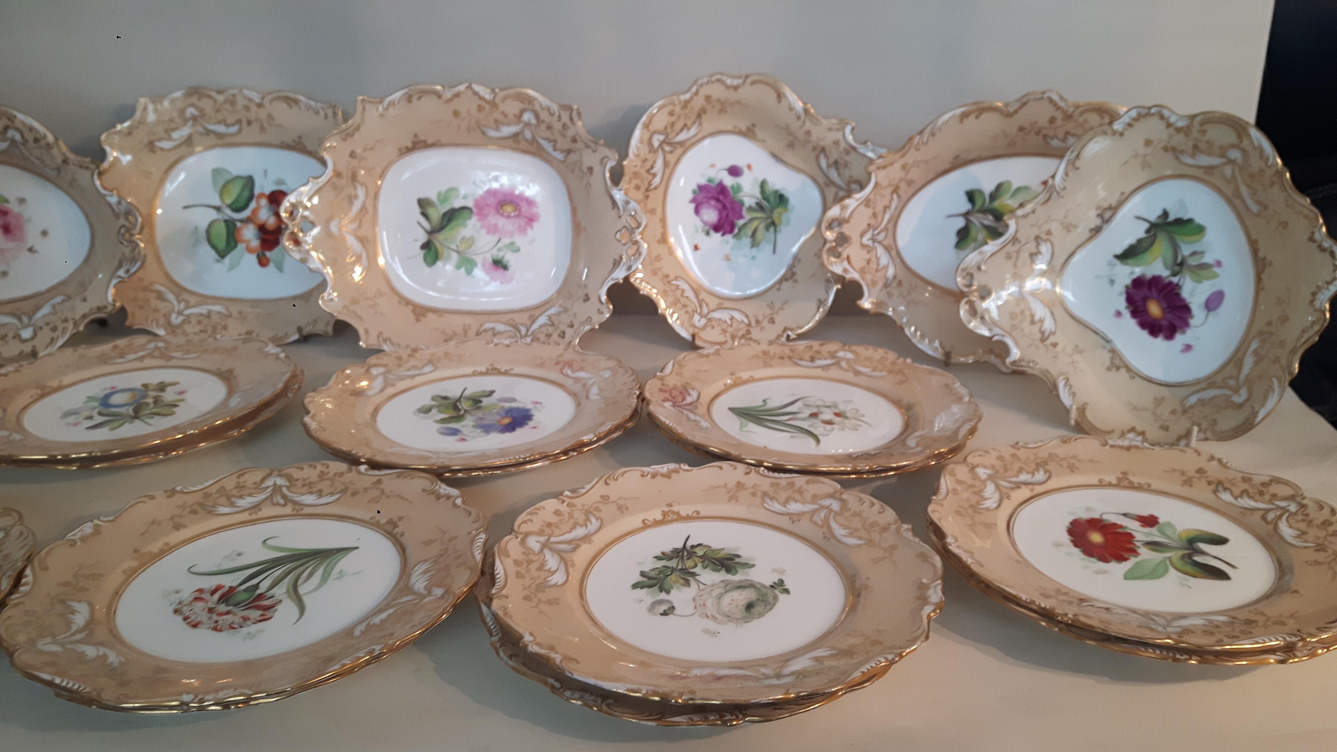 A large William Ridgway dessert service each plate hand painted with a different botanical pattern, the borders painted
in pale peach with gilded patterns of leaves and white swags
The service comprises of 14 round plates 23 cm diameter
2 oval