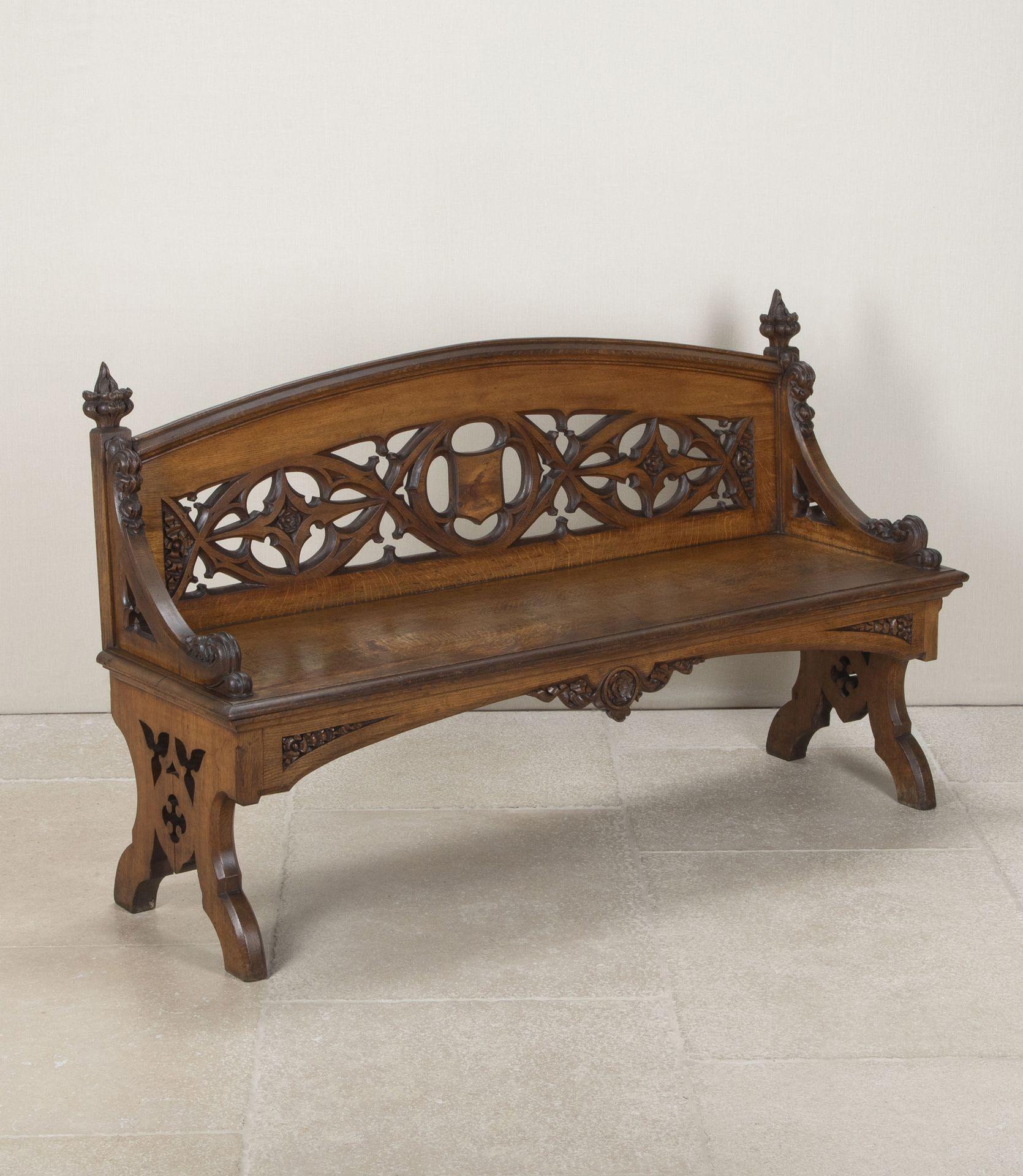 Large 19th Century English oak hall bench.
With arched back and pierced carving featuring intertwined trifold and quatrefoils. Flanked by swept arms with scroll corbels and coronet capitals. Raised on a moulded seat with pierced carved supports,