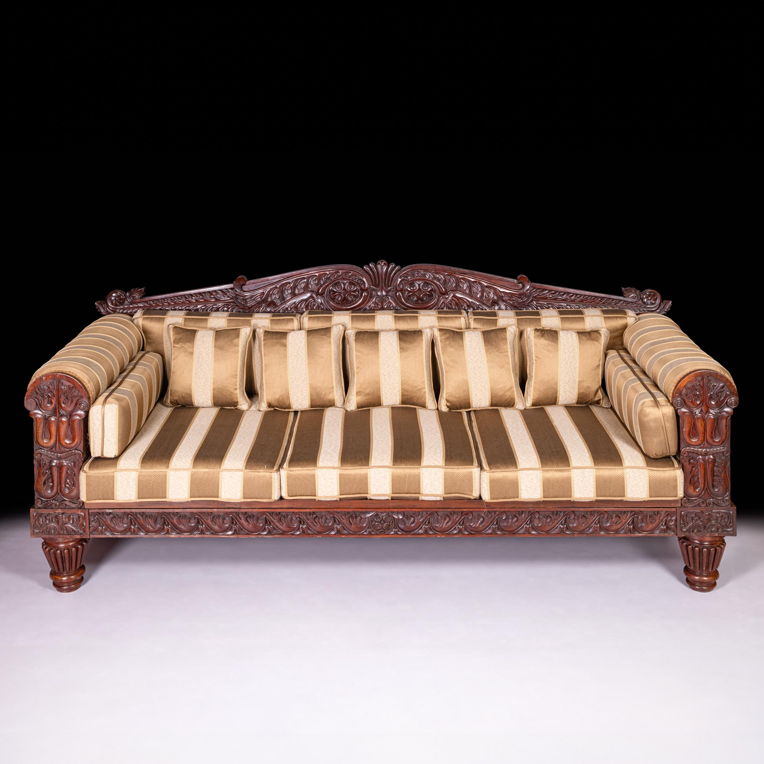 A very fine and substantial late Regency early William IV mahogany three seater sofa attributed to Gillows of Lancaster in the Grecian manner. Standing on four large bulbous style turned legs, above a carved frieze with three loose padded seat