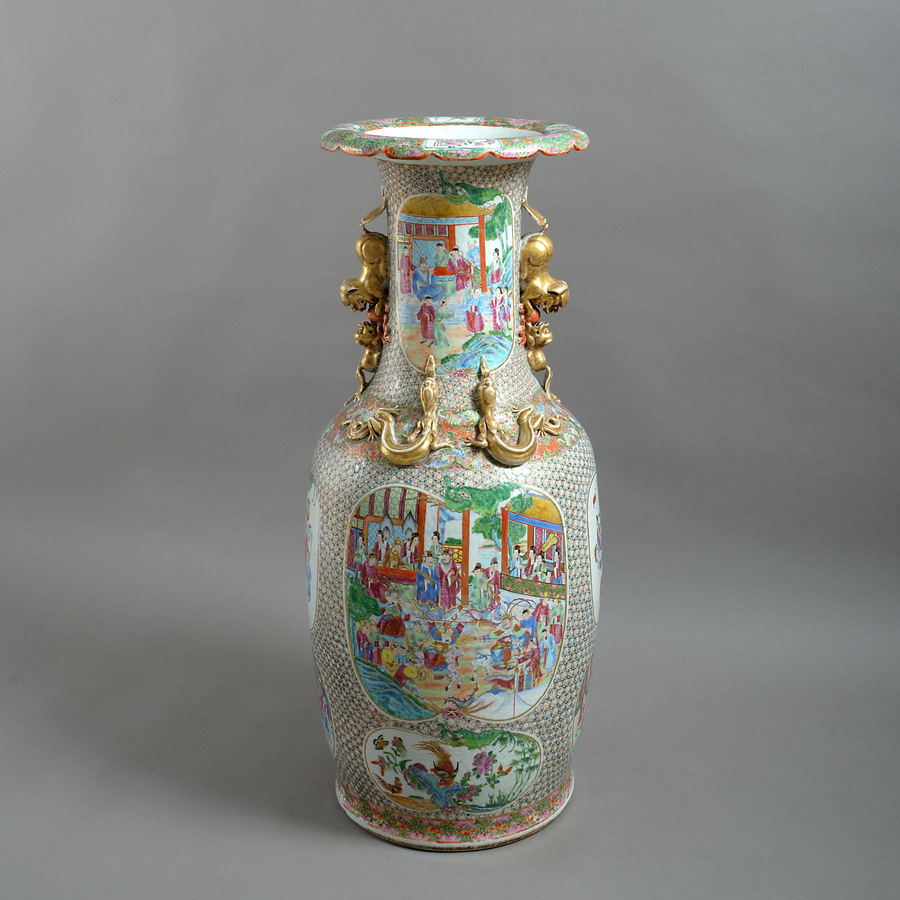 A 19th century famille rose porcelain soldier vase, the body profusely decorated with cartouches depicting court scenes, exotic birds and flowers, having a shaped rim and gilded handles. 

Late Qing dynasty.