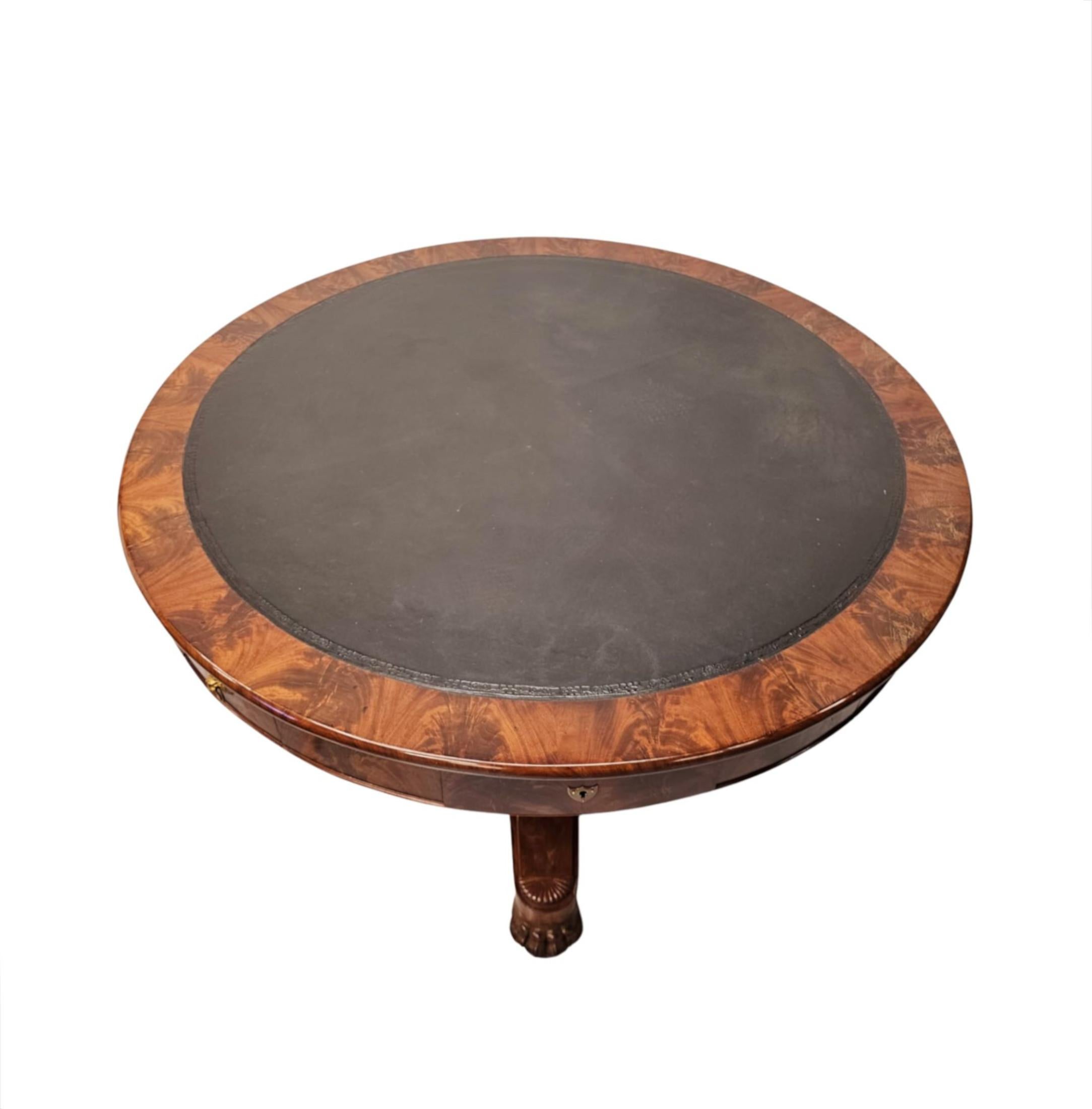 A very rare 19th Century well figured flame mahogany leather top drum centre table of grand proportions.  This exceptional piece is finely hand carved with stunningly rich patination and grain.  The moulded top of circular form is fitted with a