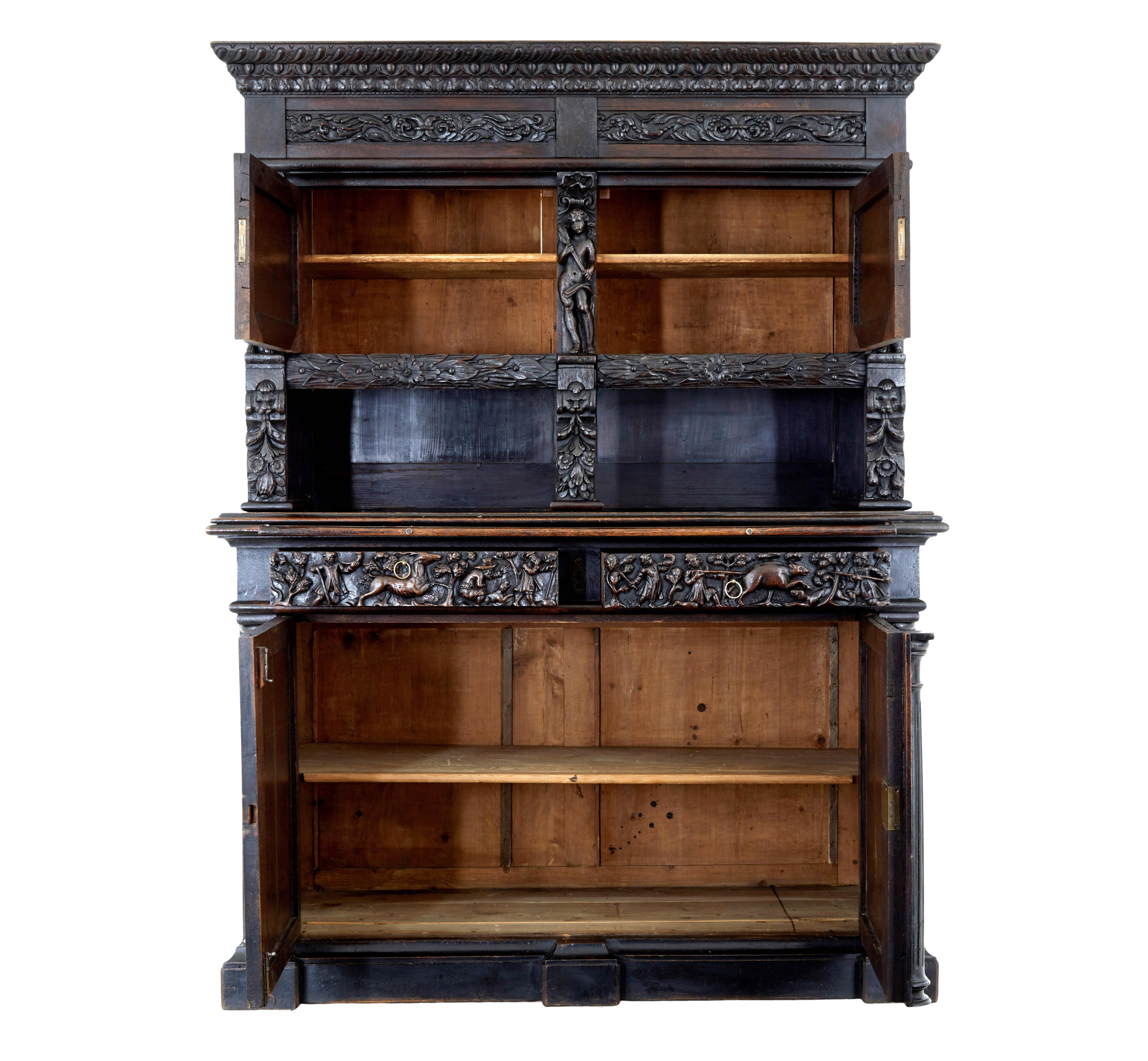 Sh carved oak cabinet circa 1870.

Profusely carved cupboard of grand proportions in the Baroque Revival taste. Comprising of 2 sections.

Understated cornice decorated with egg and dart carving with further carved panels below. Small double