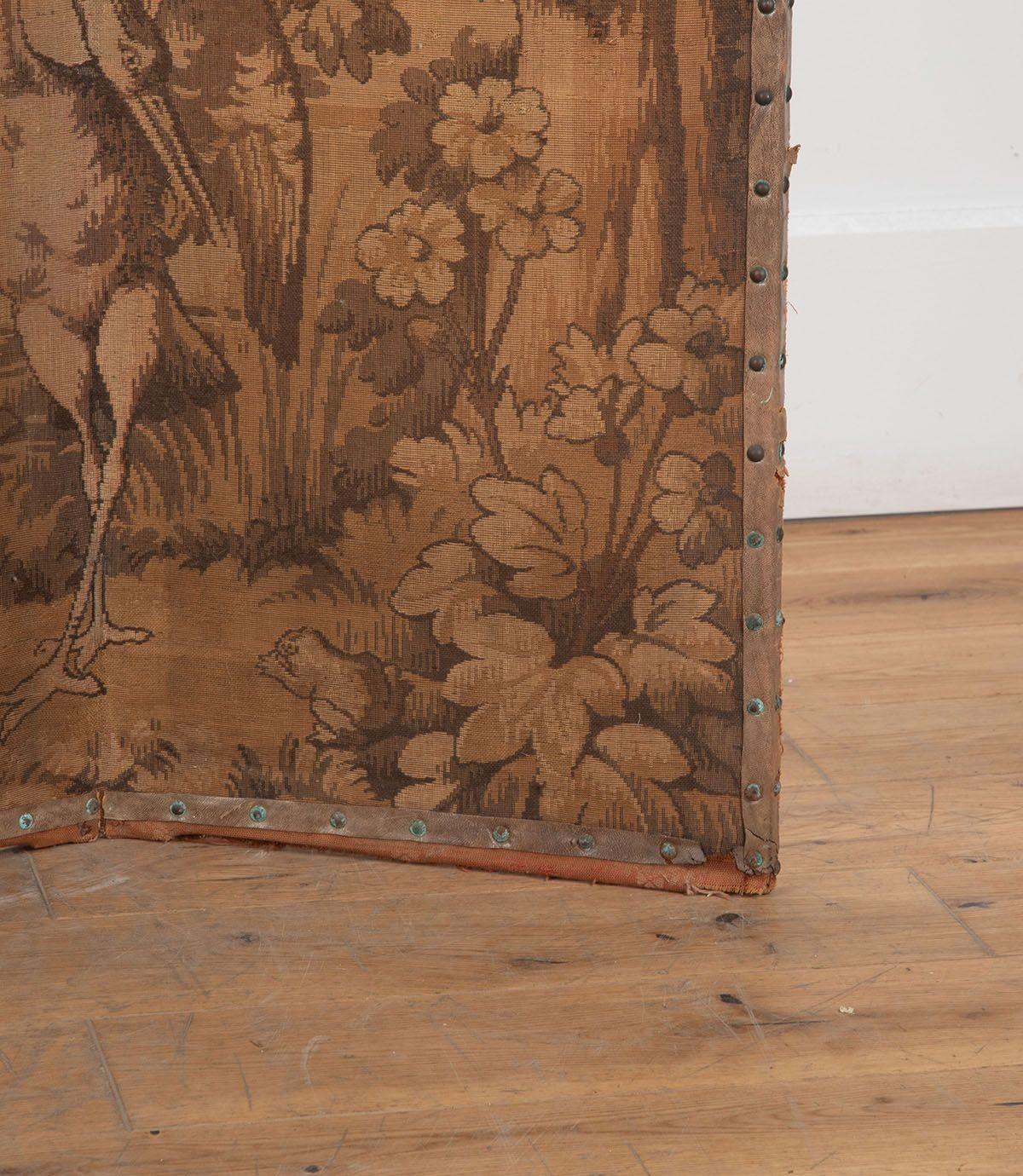 19th Century Flemish tapestry four panel room divider of large proportions depicting trees, foliage and a river with a birds and moulin in the background.

The tapestry colours have faded throughout as is usual. The screen shows wear commensurate