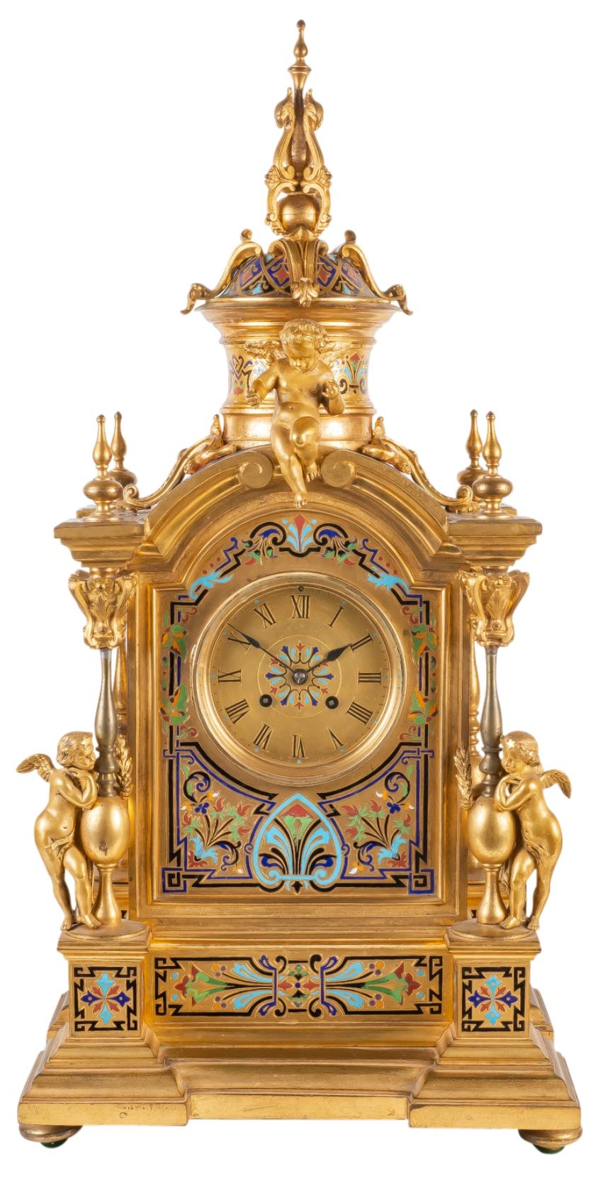 A fine quality large 19th century French gilded ormolu and Champlevé enamel clock garniture, having cherubs perched on top and to the sides, turned finials and columns. Bright coloured classical motif enamel decoration, flanked by a pair of matching