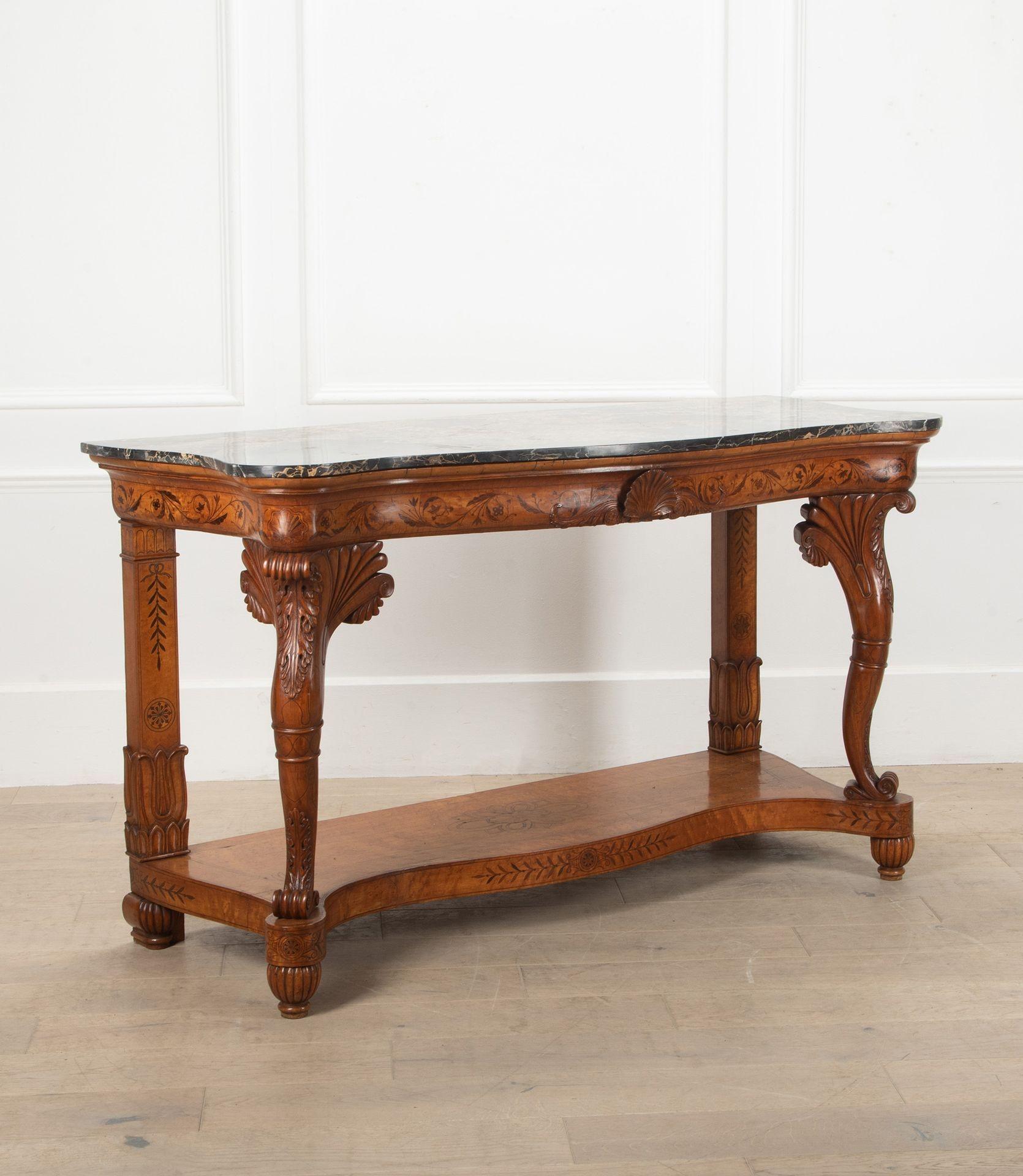 A large and elegant 19th Century French, Charles X, console table.
Featuring some stunning intricate carving, showcasing a shell motif in the centre of the frieze and a black grey marble top.