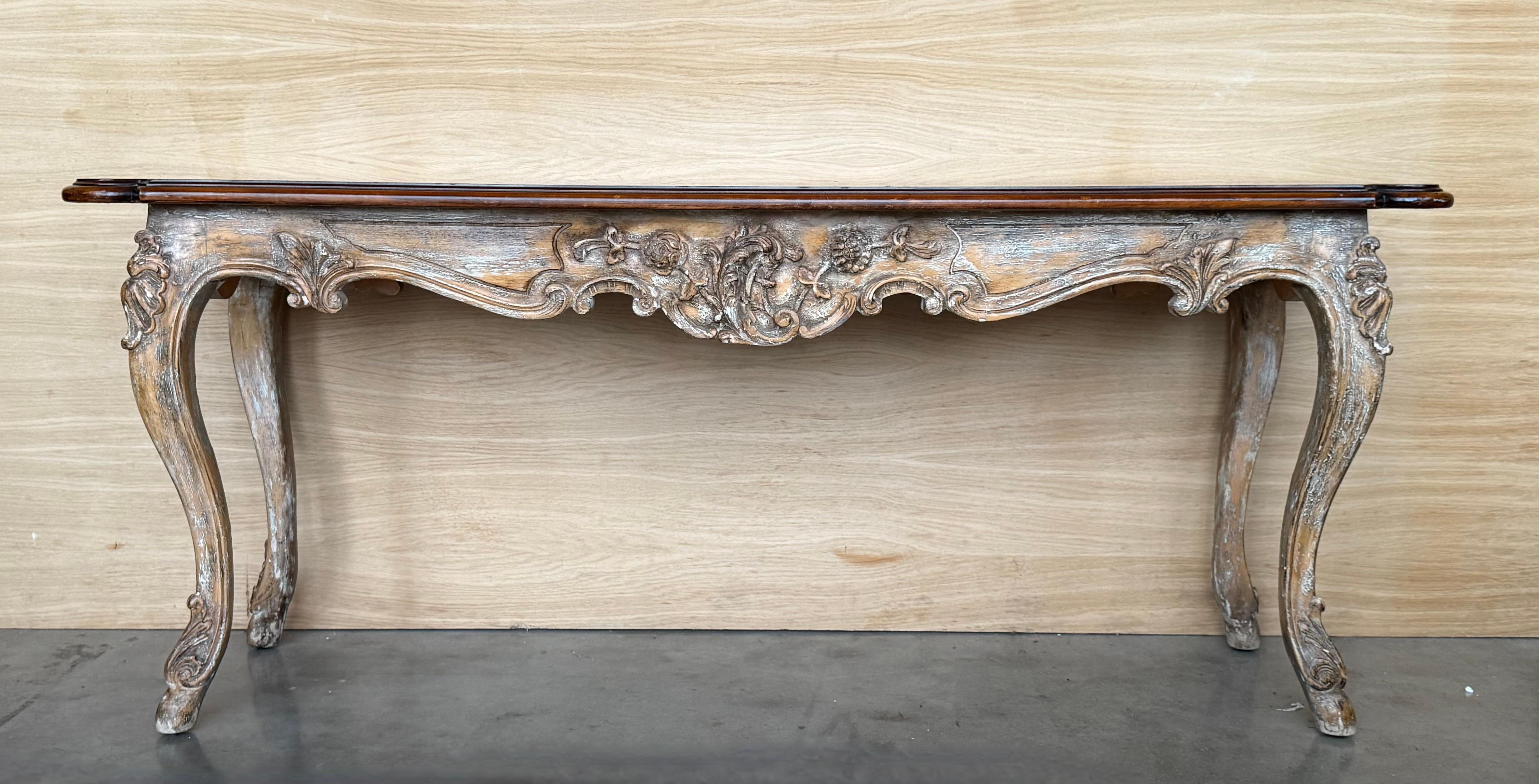 Classic, large 19th century French Louis XVI style console table in carved wood, with remnants of old white paint. The elegant console with fluted carved frieze and plaster shaped tapered legs.