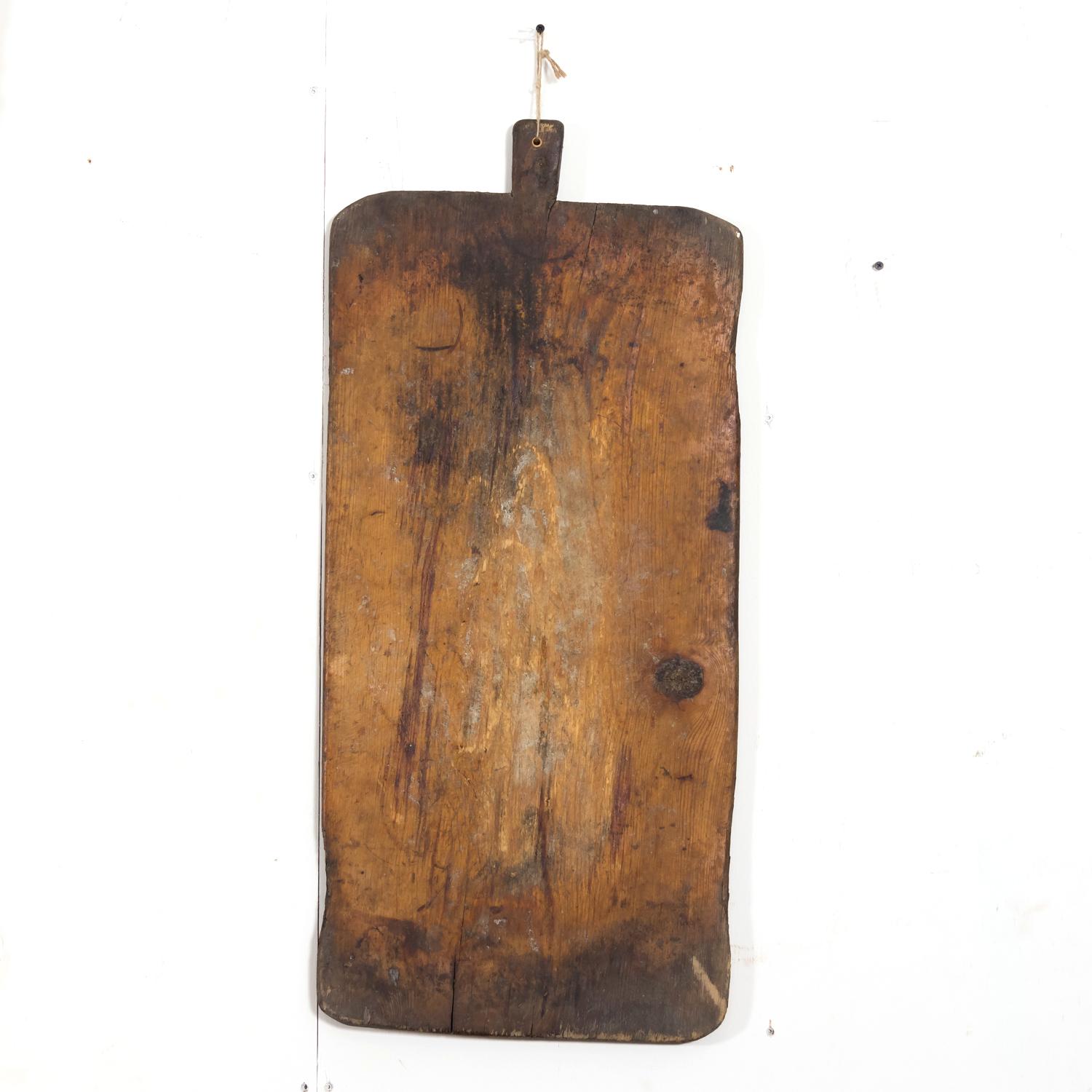 A wonderful large 19th century French cutting board with jute string for hanging, circa 1890s. Having a fantastic timeworn patina on both sides, showing knife marks and darkening that happens only after decades of use, this antique board will add a