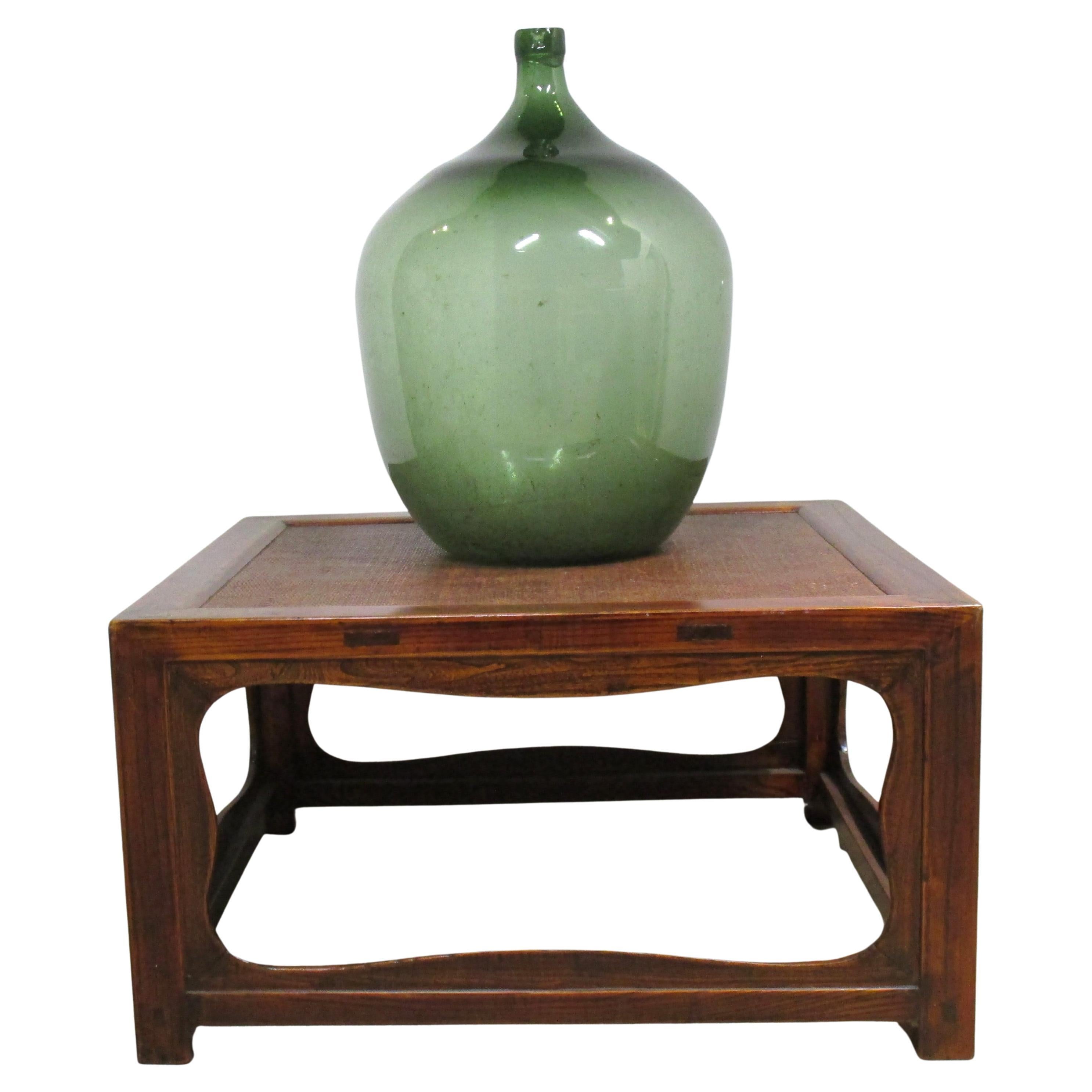Large antique blown green glass demijohn w/ a raised letter W at top of neck. Likely French in origin dating from around the late 19th century. Measures 26