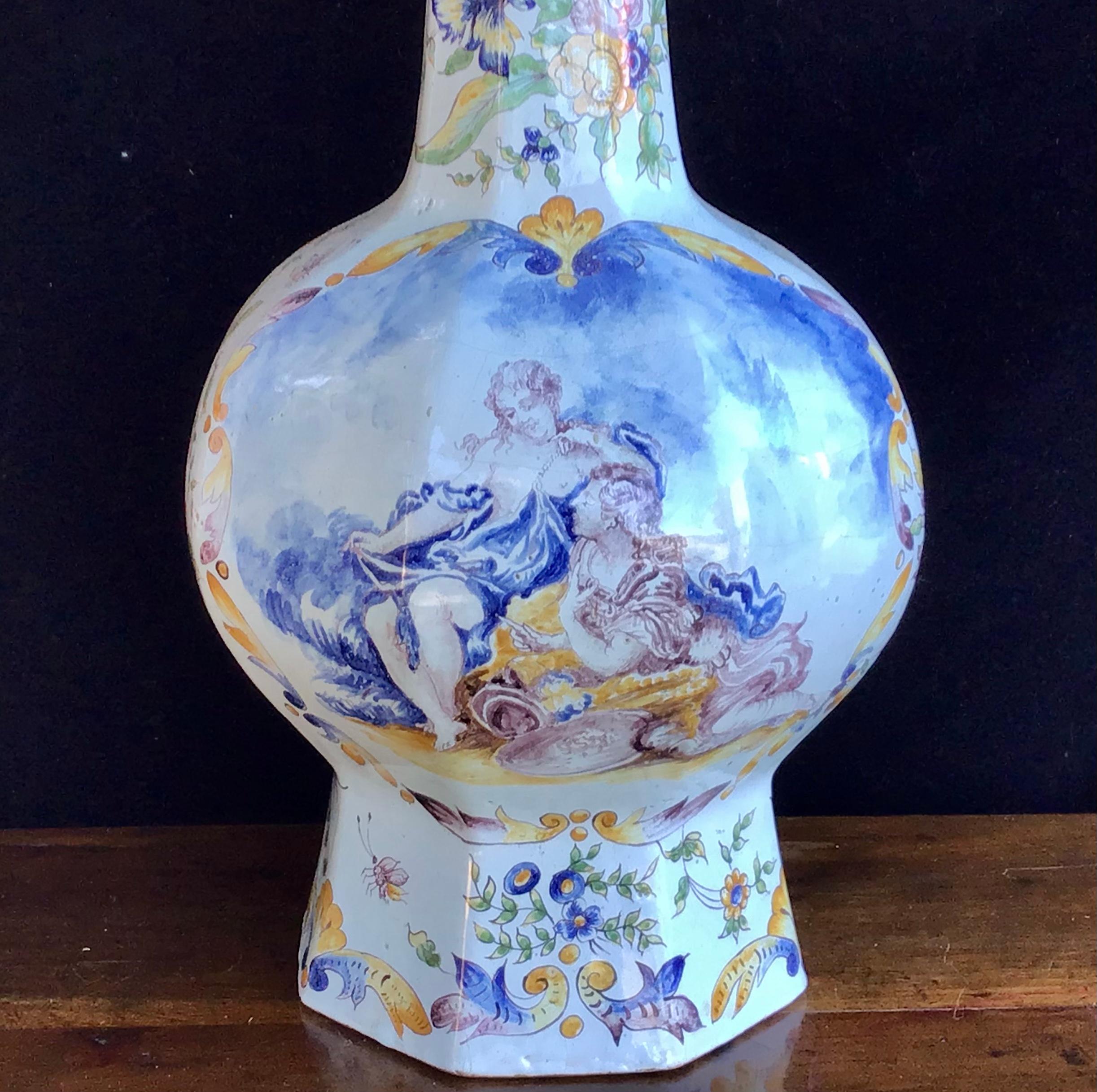 This large and beautifully decorated colorful faience vase was made in France in the 19th century. Signature on the bottom. Painted with a scene of an amorous couple on the front, the rest with very vivid floral and other decoration. 
See the last