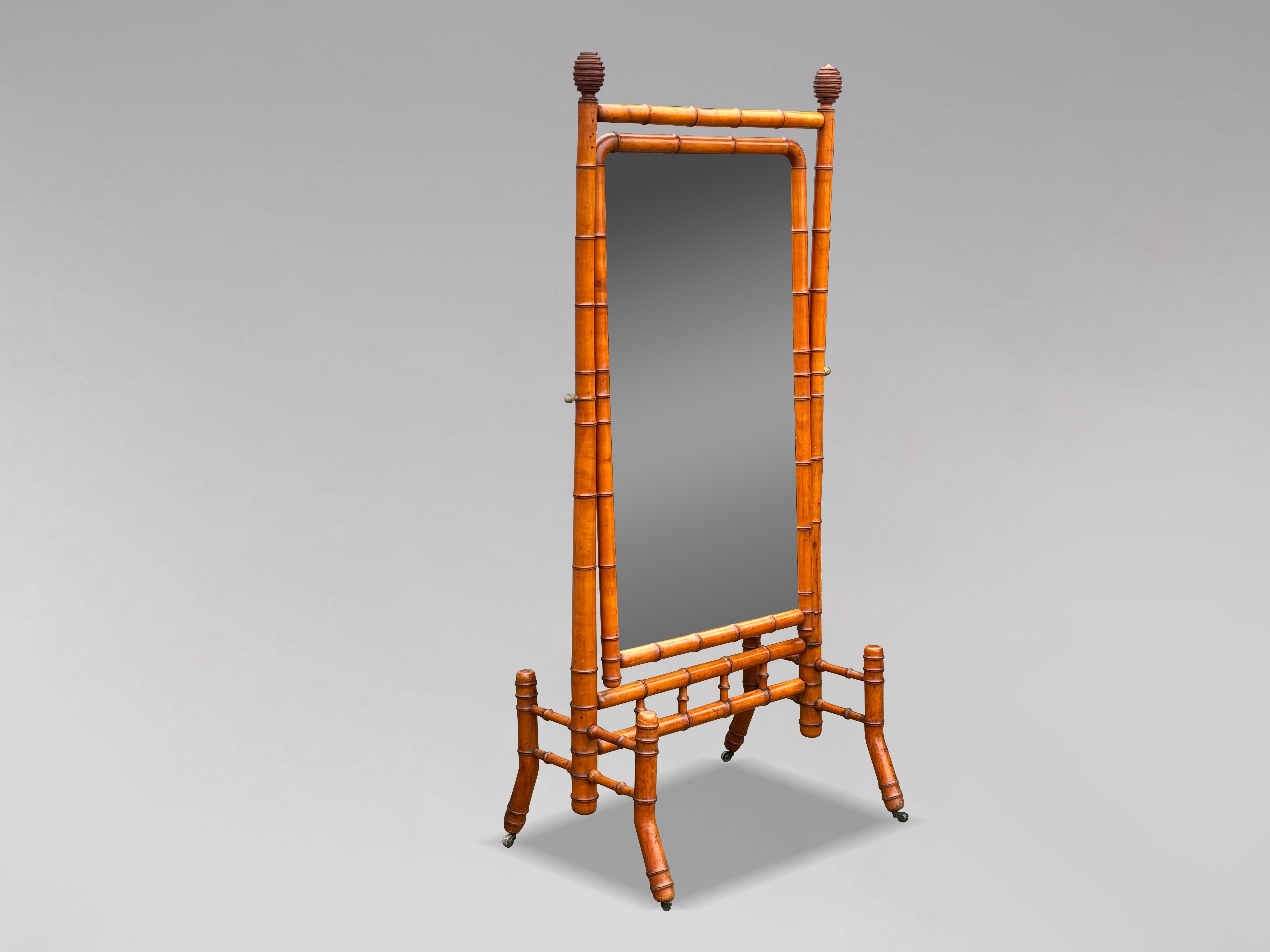 Un grand miroir de cheval ou de coiffeuse en faux bambou français de la fin du 19e siècle, d'une qualité exceptionnelle. La plaque de miroir d'origine aux coins supérieurs incurvés, encadrée d'orme tourné et teinté pour ressembler au bambou, est