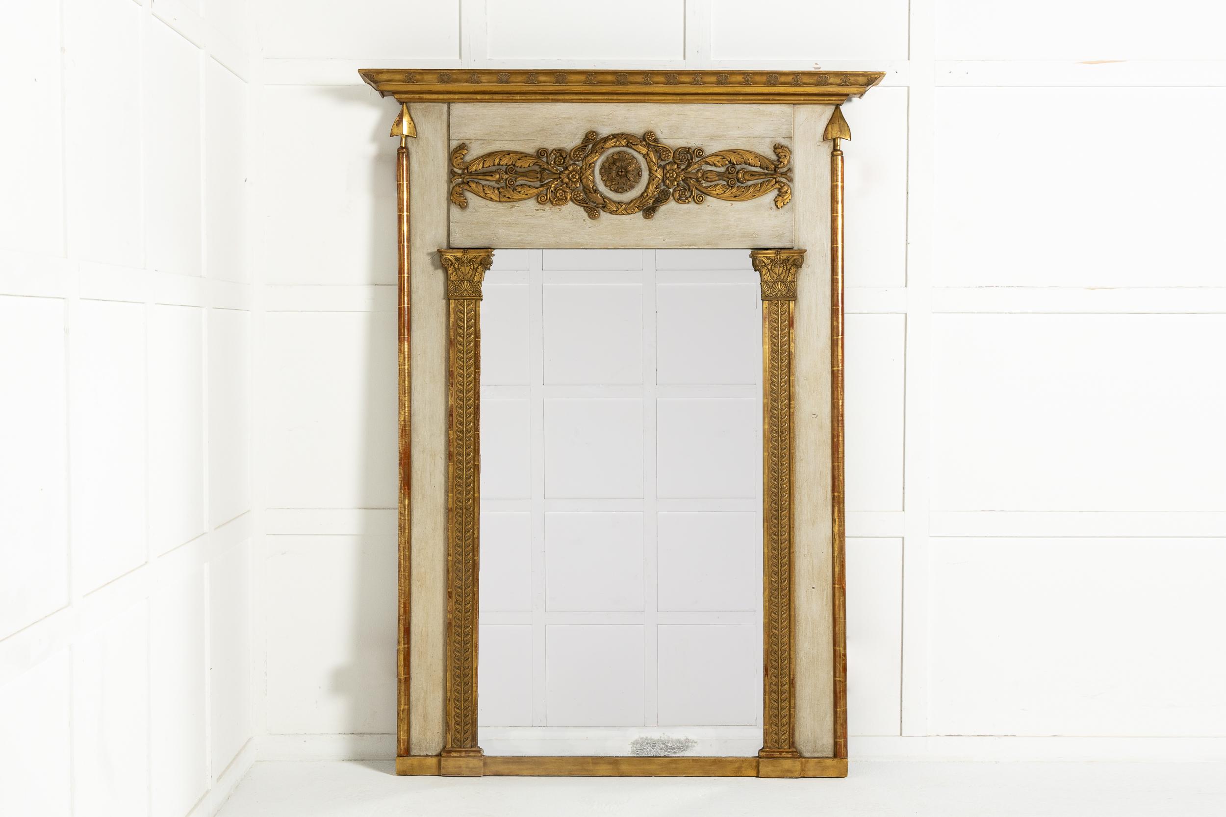 An exceptional model of a large 19th century French mirror with its original paint, gilt and glass. Having a cornice top with relief carvings and large decorative foliate carvings with a central rosette in the frieze below. The glass is flanked by