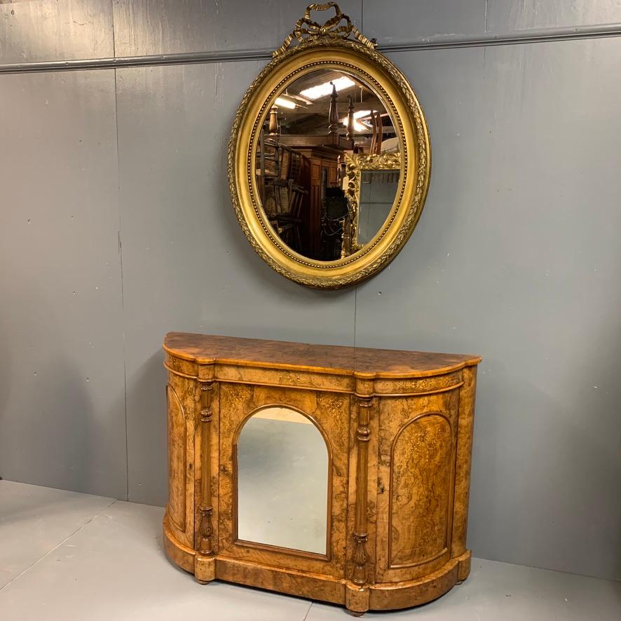 Good size French late 19th century oval gilt mirror with its original beveled mirror plate.
Good decorative frame and ribbons to the top.
Some very minor knocks over its lifetime, but nothing of any concern.
The gilding is clean and a good mellow