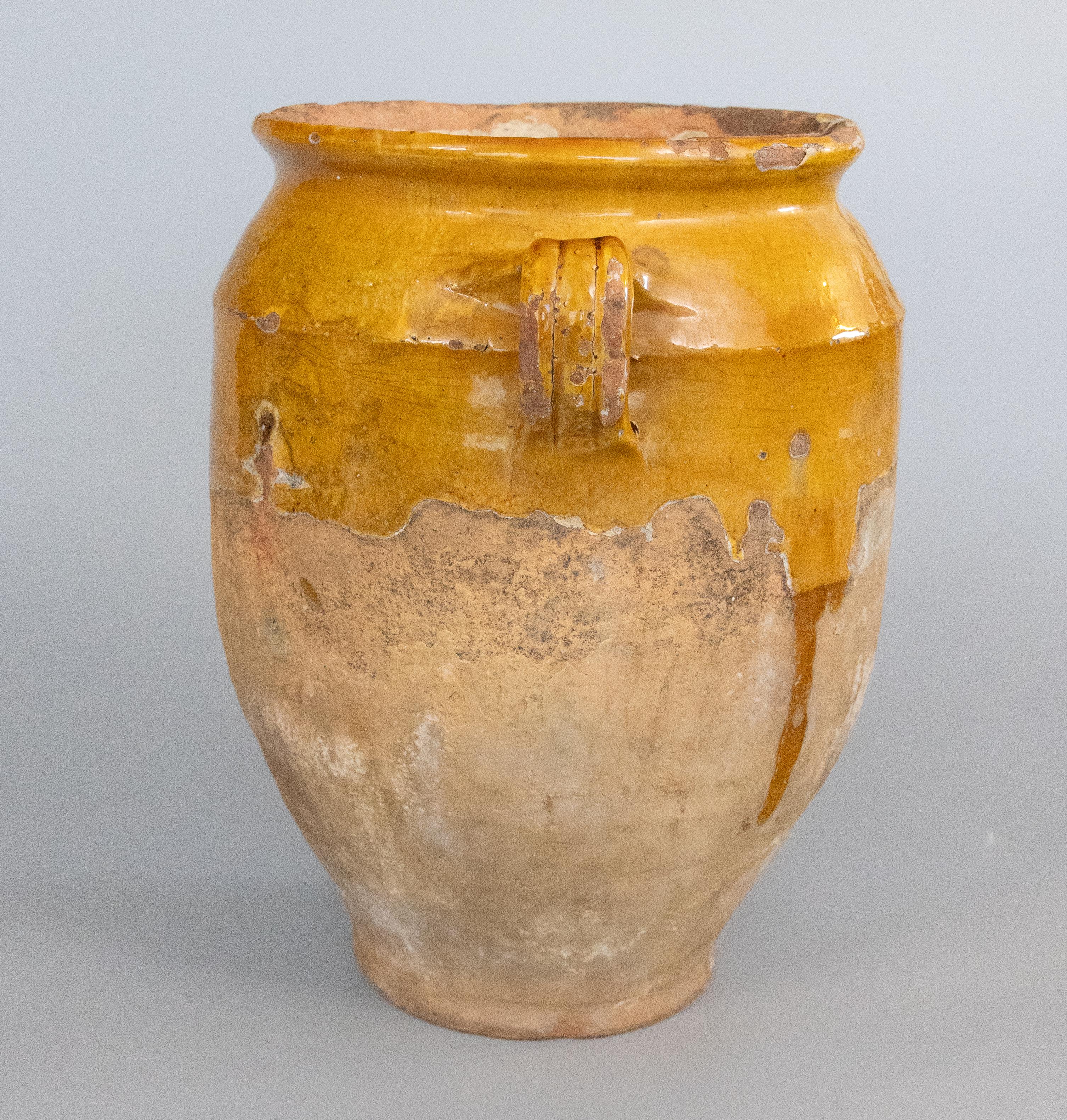A lovely large antique 19th century French confit pot with drippy mustard yellow glaze from the South of France, Castelnaudary. There is a drainage hole on the base. This pot or planter is hand thrown with charming handles known as 'ears'. These