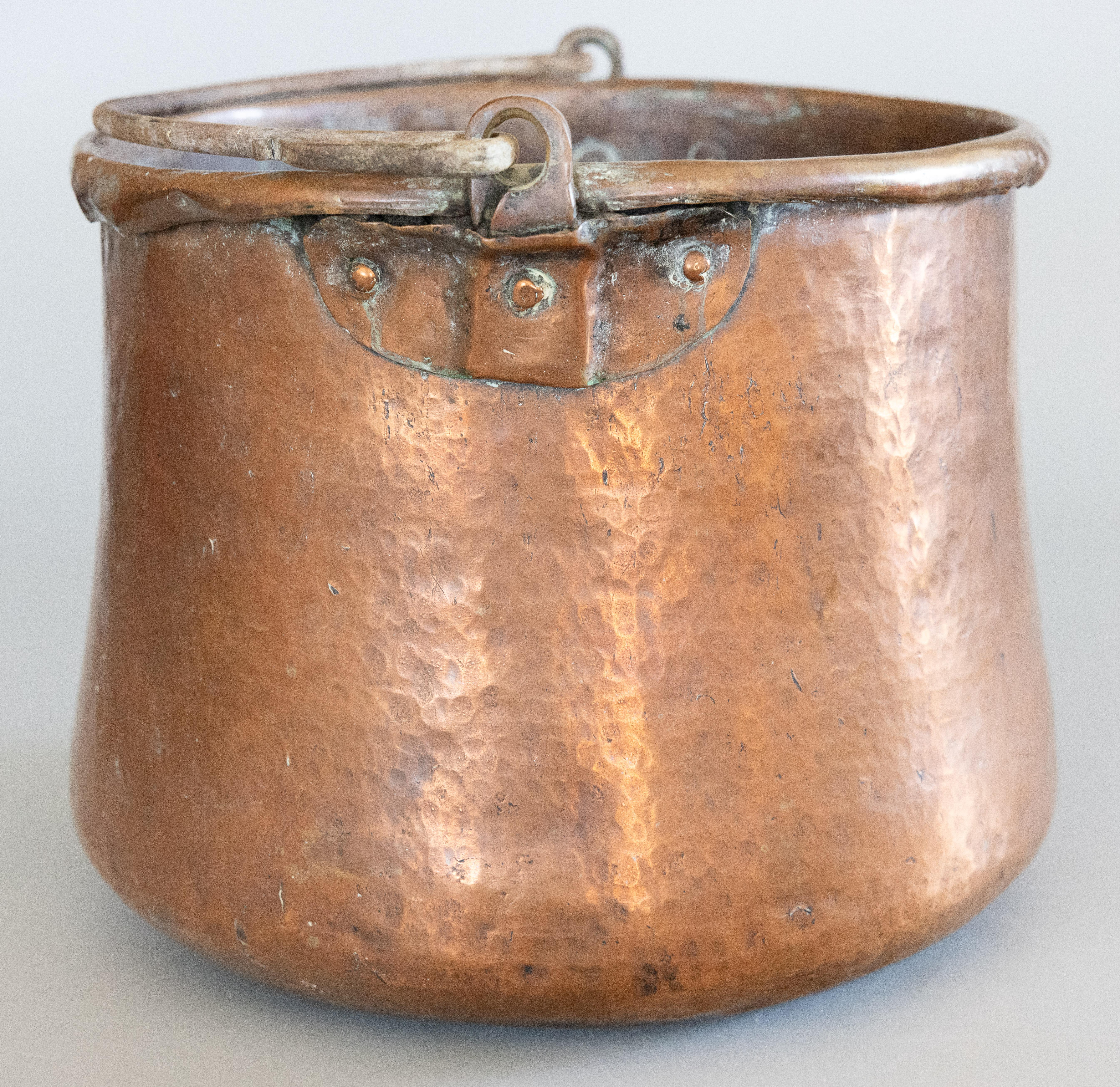 Un grand chaudron ancien du 19ème siècle en cuivre martelé riveté avec une charmante poignée en fer forgé. Il s'agit d'un authentique pot en cuivre rouge martelé à la main datant du 19e siècle et provenant de Normandie, France. Il est solide et