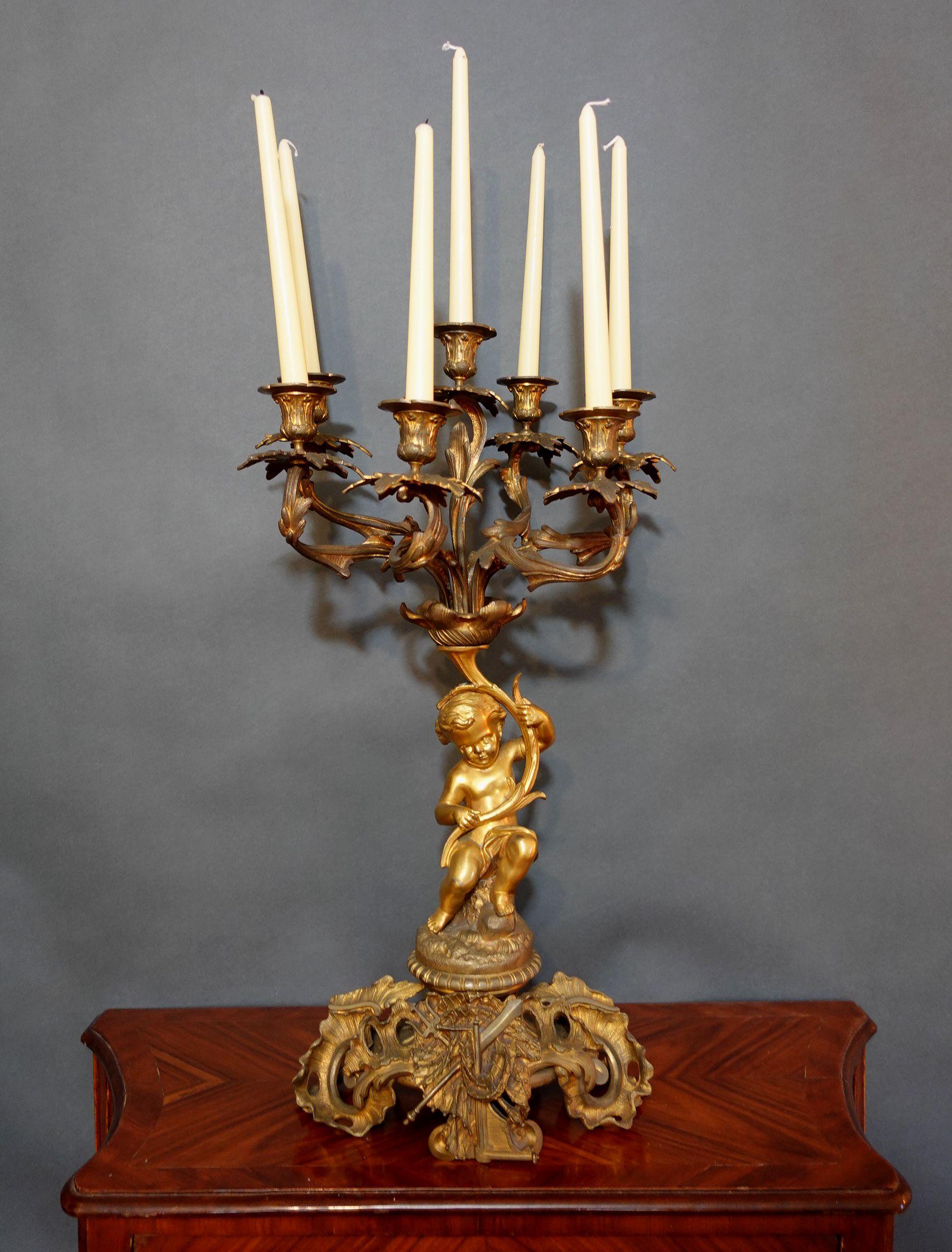 Großer und schwerer französischer Kerzenleuchter im Louis XV-Stil aus Bronze mit komplizierter skulpturaler Form, die sich durch das gesamte Stück zieht.
Spezieller Vergoldungseffekt auf dem Körper der Putte, um diese Figur sehr sichtbar zu machen