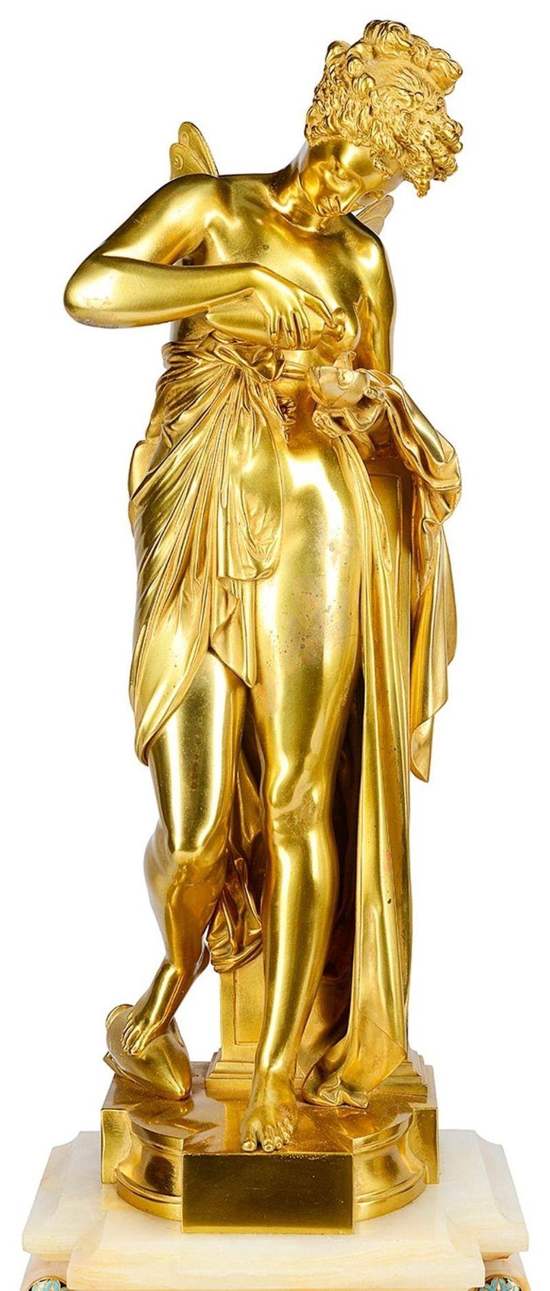 Très belle pendule française du XIXe siècle en bronze doré, émail champlevé et onyx. Whiting une impressionnante paire de candélabres à six branches avec des urnes en onyx blanc, insérées dans des bandes d'émail champlevé. La pendule présente une
