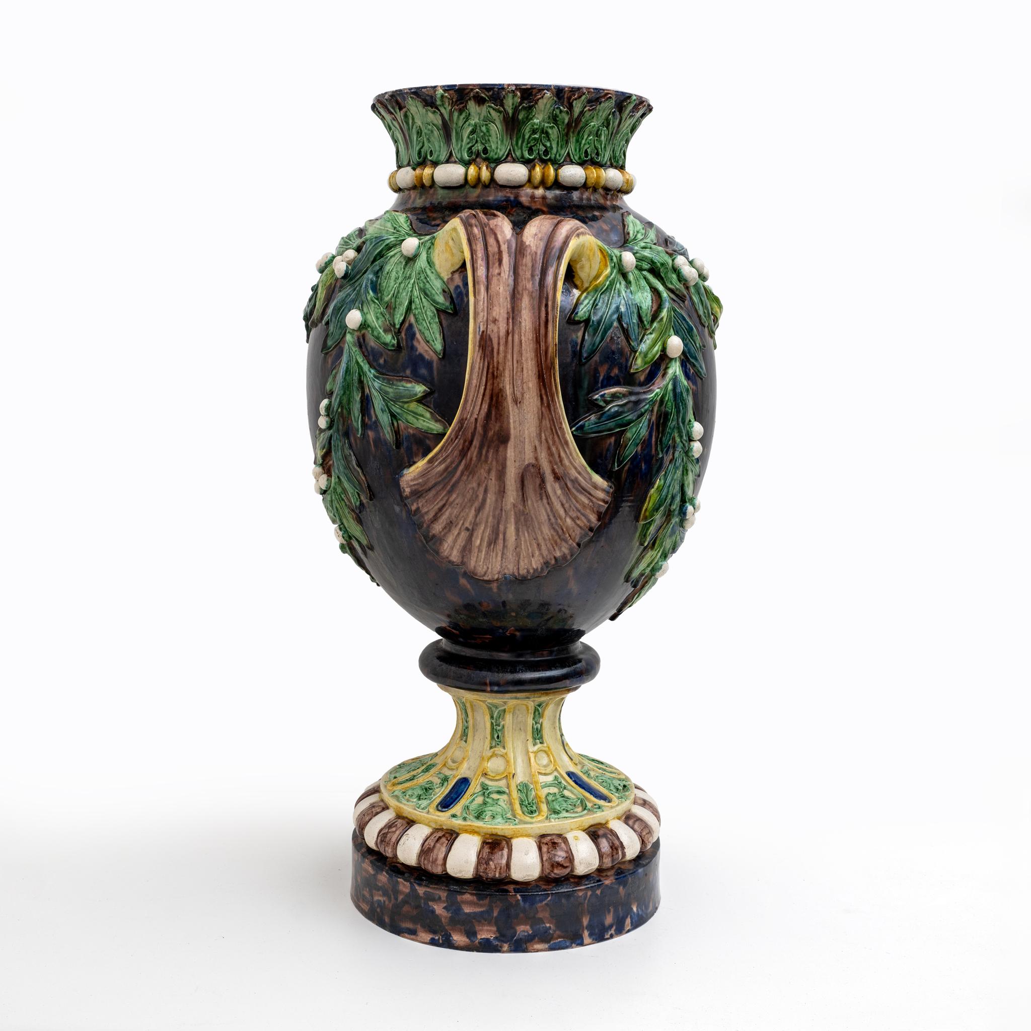 Rare et grand vase en majolique de Palissy, France, vers 1880.

Réalisé sur une base circulaire, le vase balustre à fond marron marbré repose. Le col et le pied présentent des motifs inspirés de l'antiquité classique avec des feuilles d'acanthe, des