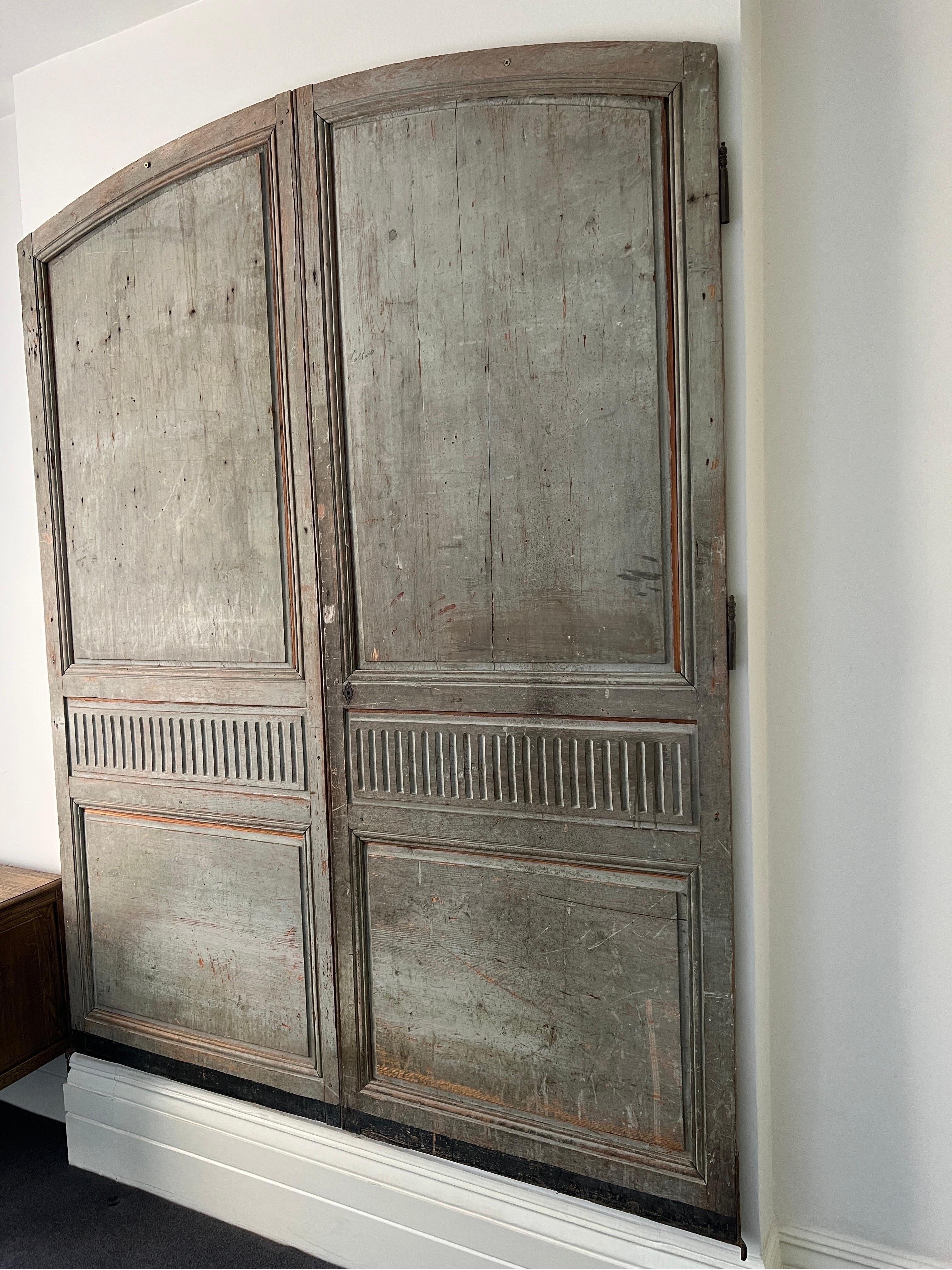 An elegant 19C pair of tall French provincial panelled doors in beautifully faded stone grey polychrome paint.
Each door measuring H225cm W92cm . 