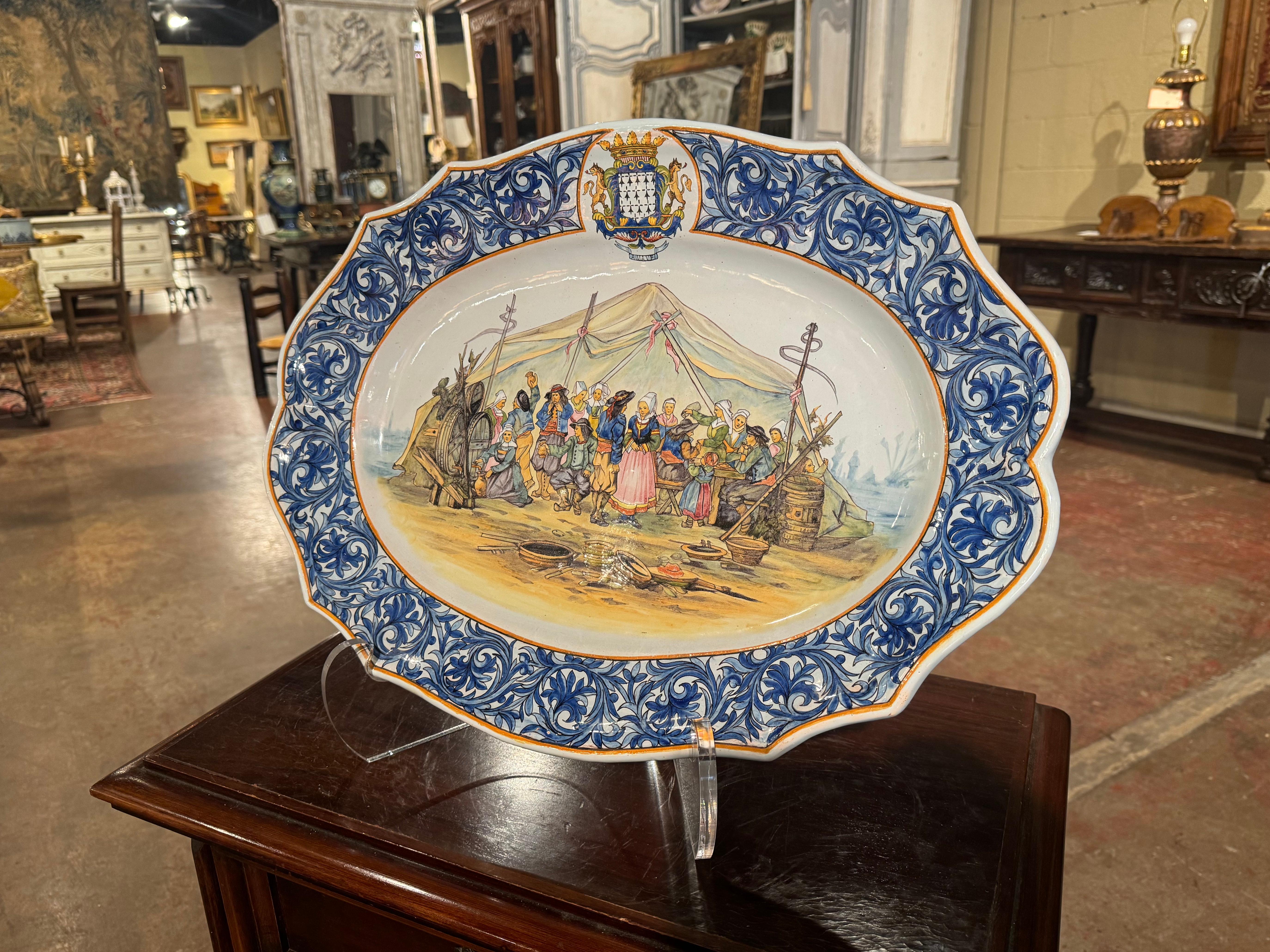 Décorez un mur de cuisine ou une étagère avec cet important plateau ancien. Créée par Porquier Beau à Quimper, en France, vers 1895, cette grande assiette en céramique peinte à la main représente une scène de mariage traditionnel avec des Bretons en