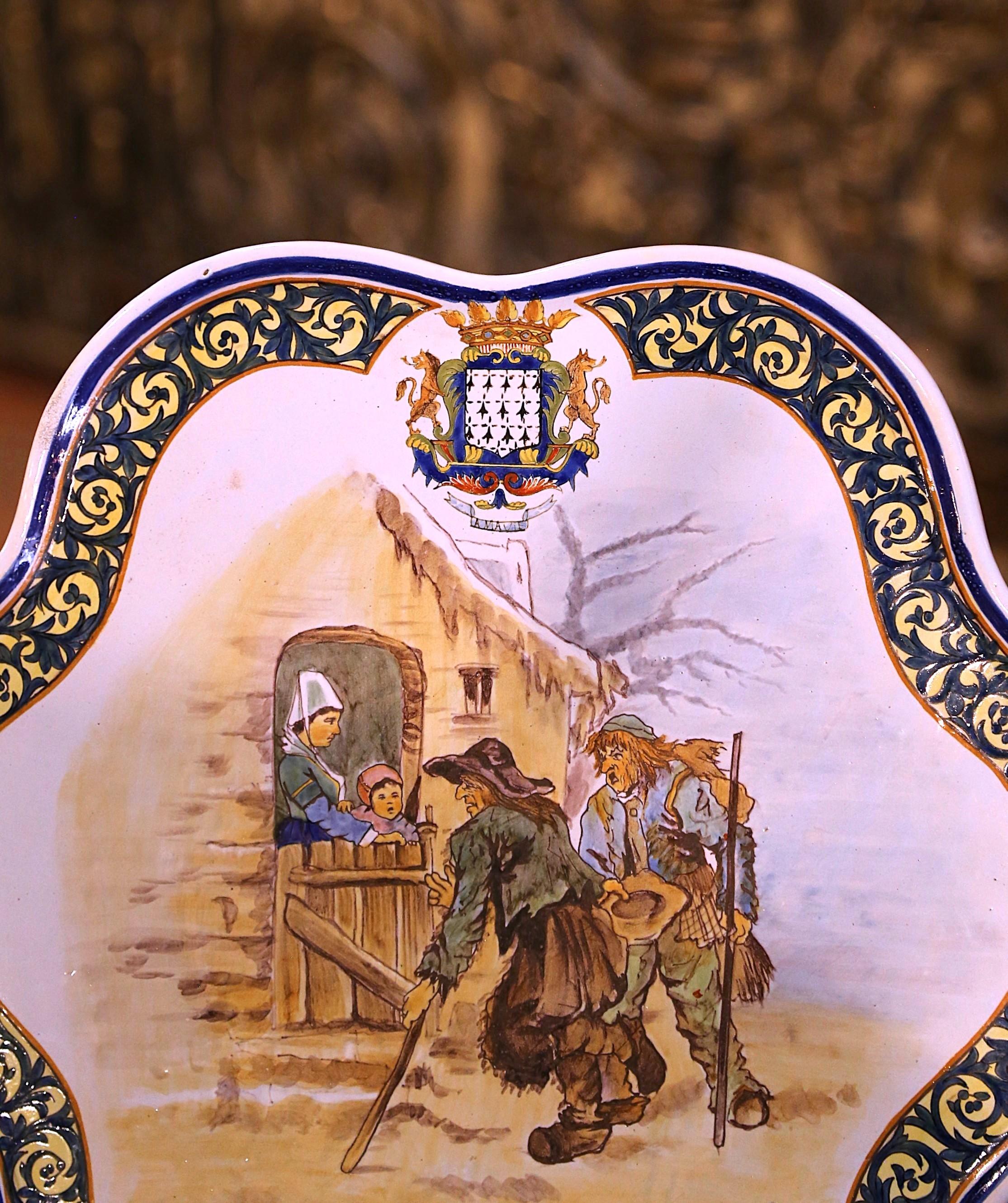 Decora una parete della cucina o una mensola con questo importante piatto da parete antico. Creato da Porquier Beau a Quimper, in Francia, intorno al 1895, il grande piatto in ceramica dipinto a mano raffigura due mendicanti che chiedono aiuto. Il