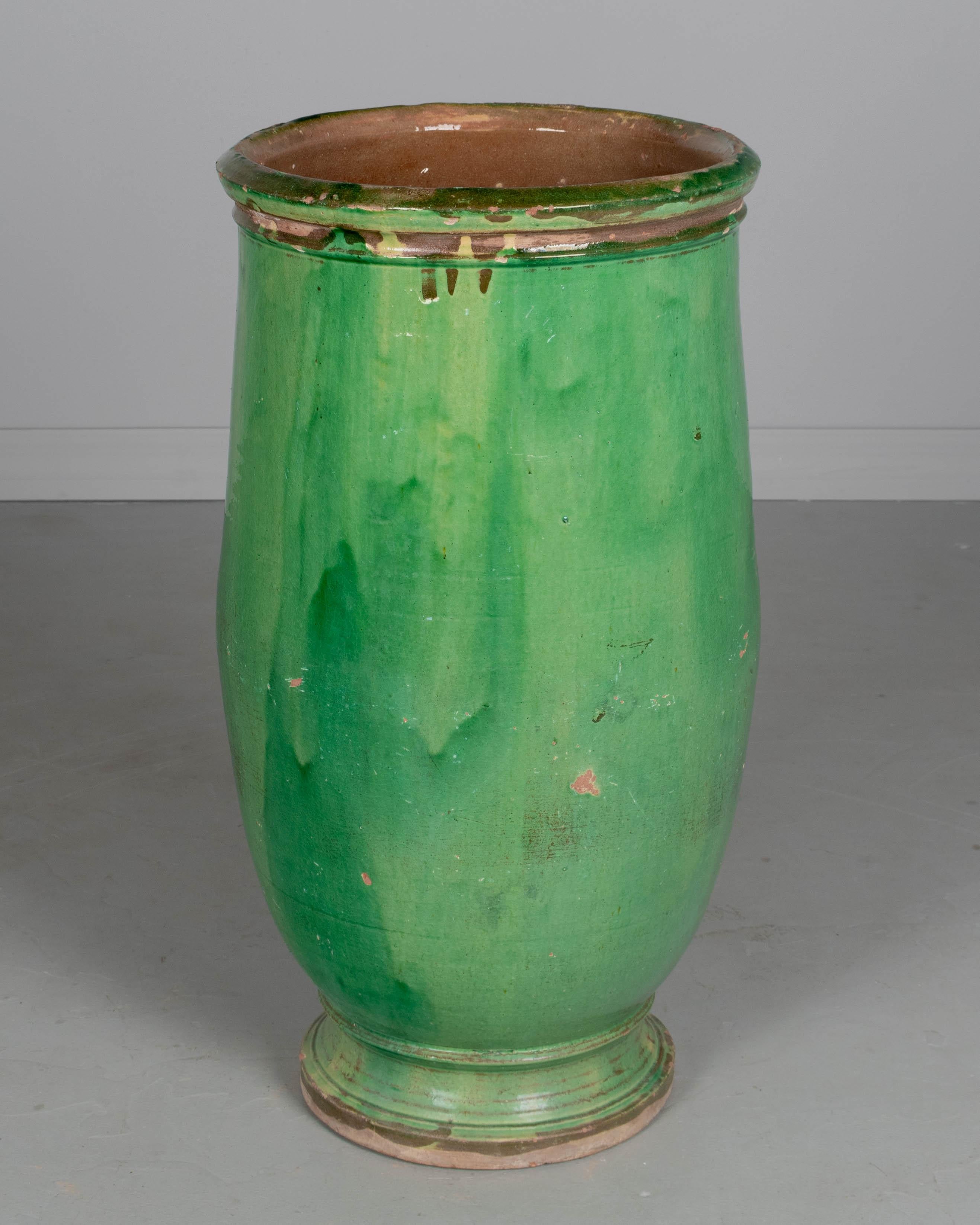 Ein großer Olivenölkrug aus grün glasierter Terrakotta aus dem 19. Jahrhundert aus dem Südwesten Frankreichs. Geringfügige Glasurverluste und abgesplitterter Rand. Eine schöne Gartendekoration, ein Brunnen oder ein Pflanzgefäß für den Innen- oder