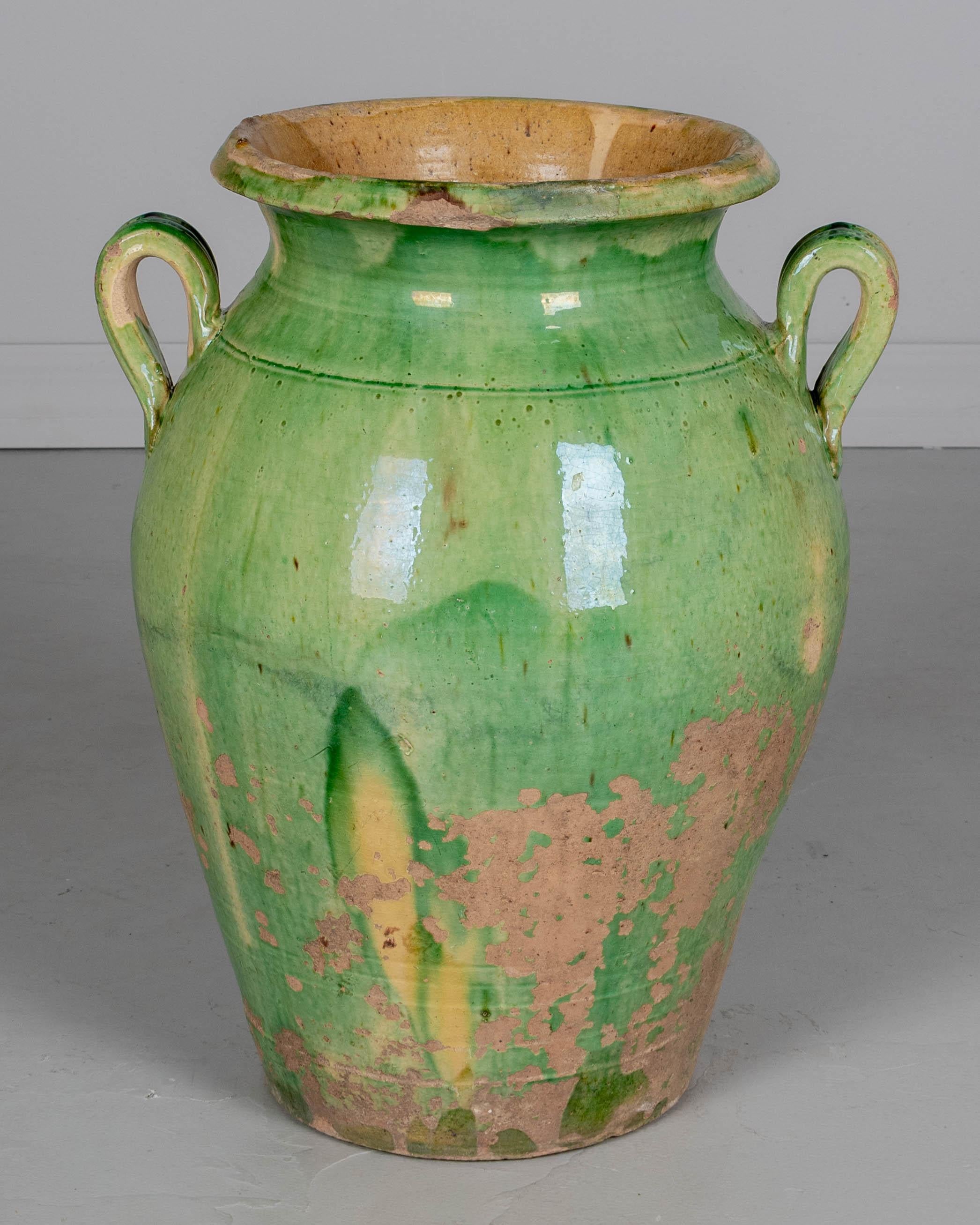 Ein großer Olivenkrug aus grün glasierter Terrakotta aus dem 19. Jahrhundert aus dem Südwesten Frankreichs. Geringfügige Glasurverluste und abgesplitterter Rand. Eine schöne Gartendekoration, ein Brunnen oder ein Pflanzgefäß für den Innen- oder