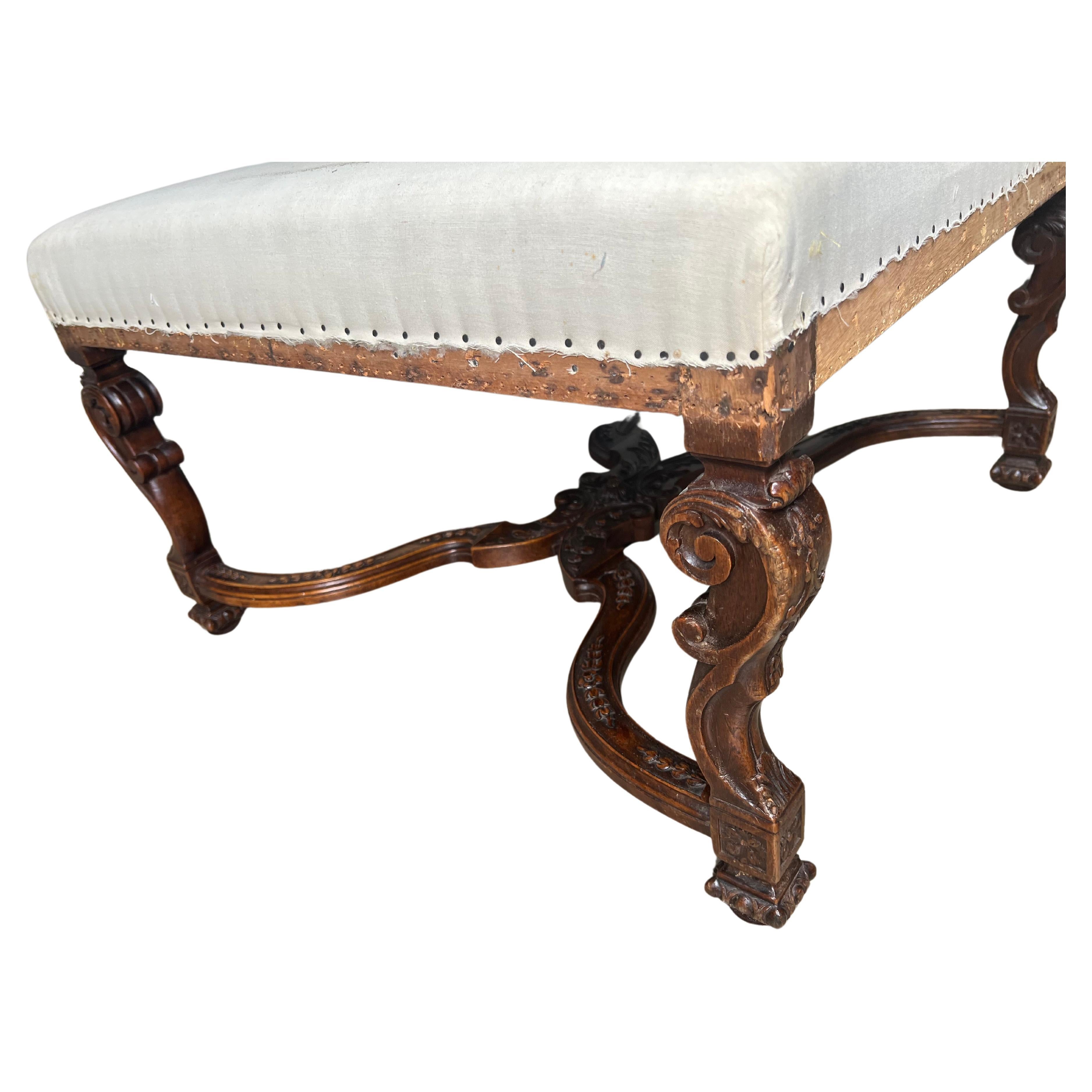A large French late 19th century carved walnut Regence style ottoman, tabouret.  This ottoman is beautifully carved with an X stretcher and scrolled legs.  It is very decorative and functional and could double as a coffee table with tray.  The seat