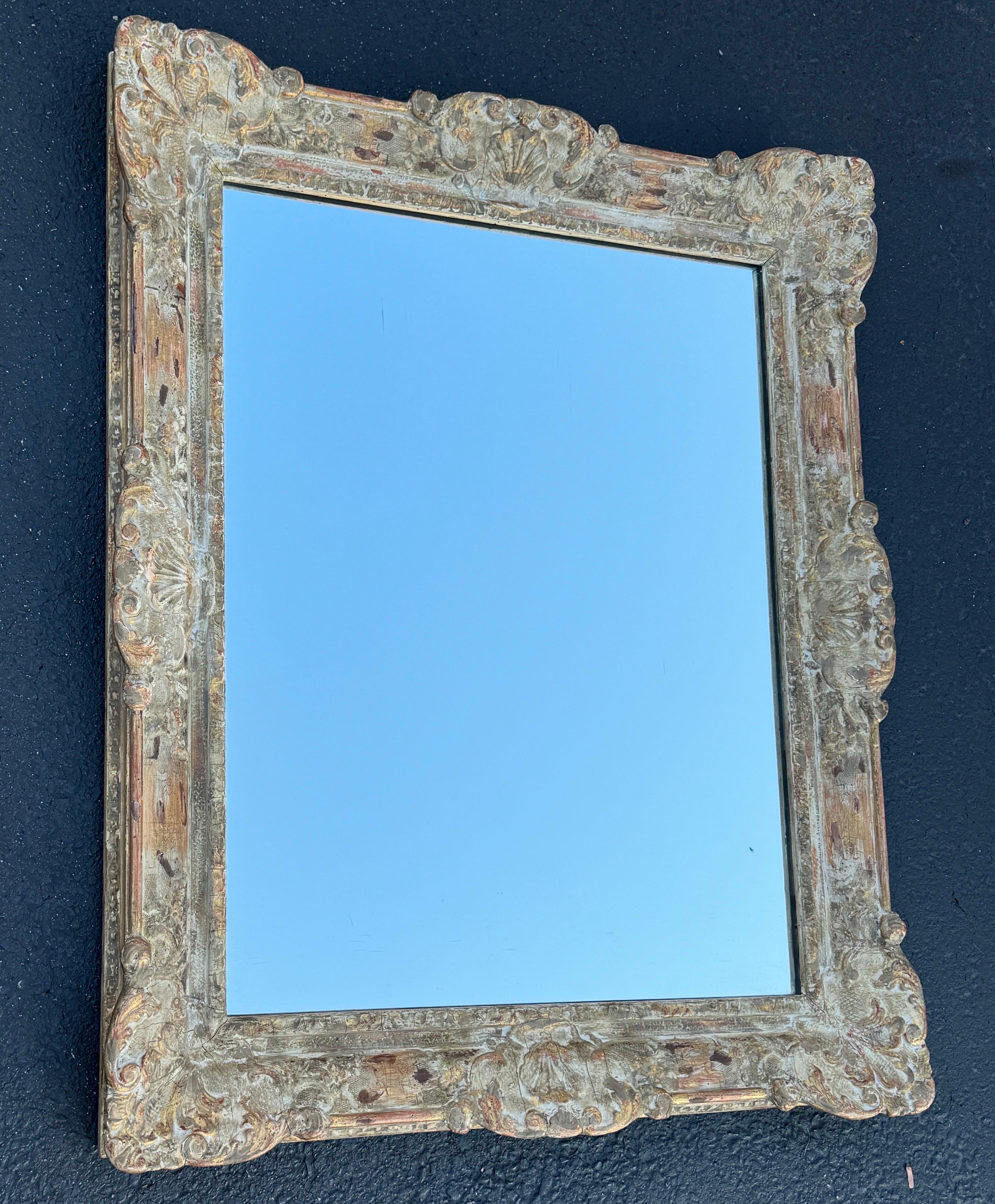 Specchio dorato e dipinto intagliato a mano proveniente dalla Francia. Questo specchio presenta bellissimi motivi floreali rococò. È sicuramente un pezzo versatile che può essere utilizzato in una sala da pranzo formale o informale, in un soggiorno,
