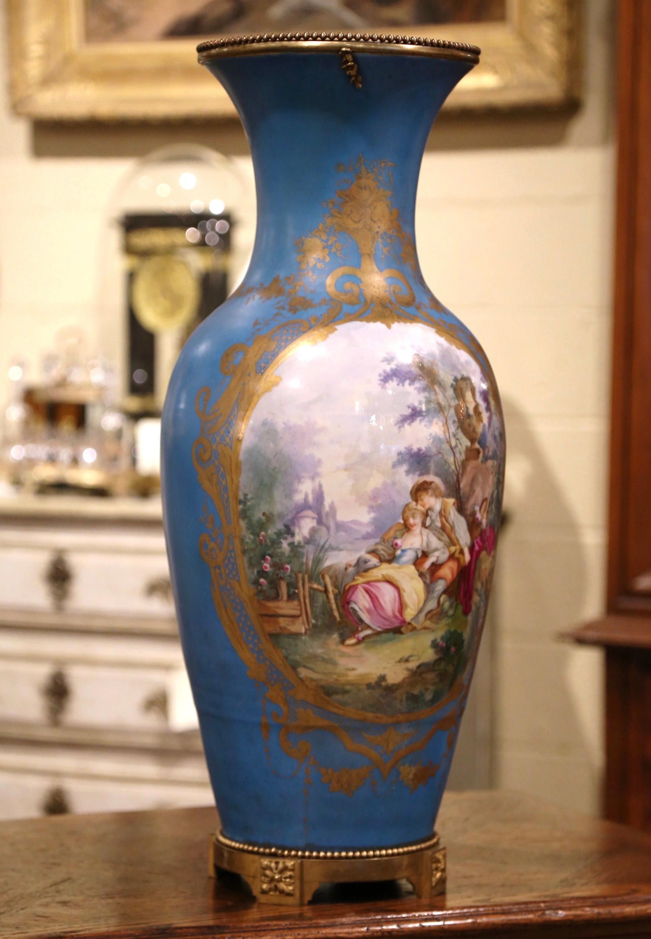 This monumental Louis XVI Sèvres vase was created in Paris, France, circa 1860. Standing on a bronze base, the tall porcelain vessel features a hand painted romantic scene in the manner of Boucher, with a gentleman courting a young beauty. The